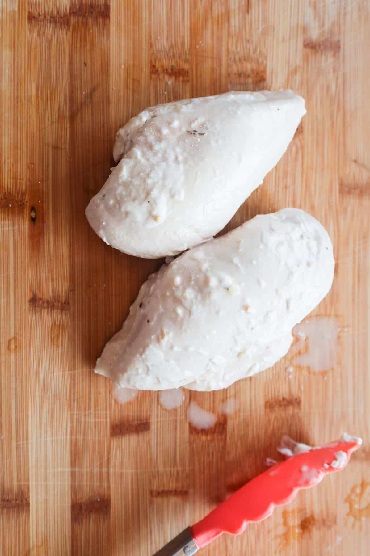 cooked chicken breasts on a cutting board