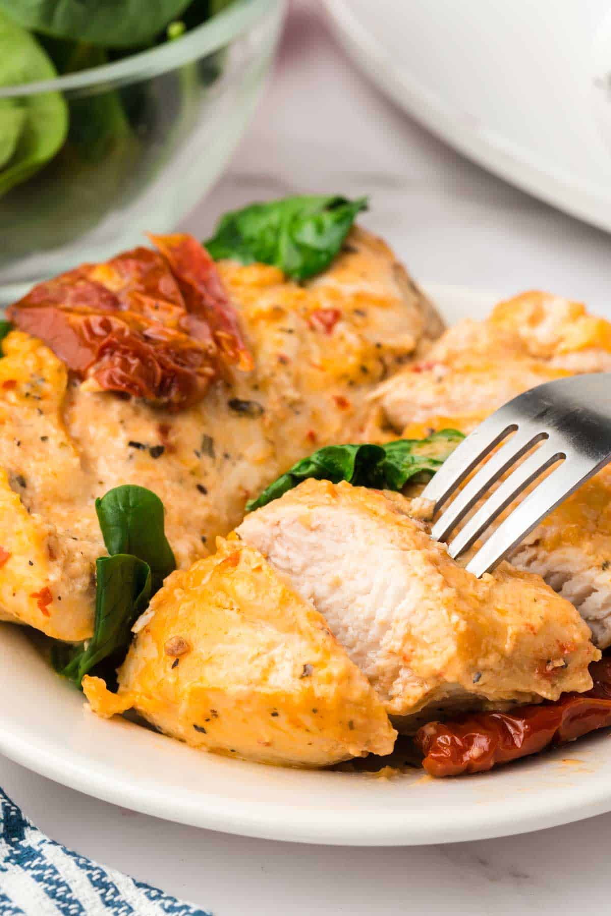 Crock Pot Tuscan Chicken is an easy slow cooker chicken dinner recipe made with boneless, skinless chicken breasts and loaded with spinach, sundried tomatoes, cream of chicken soup, tomato sauce and parmesan cheese.