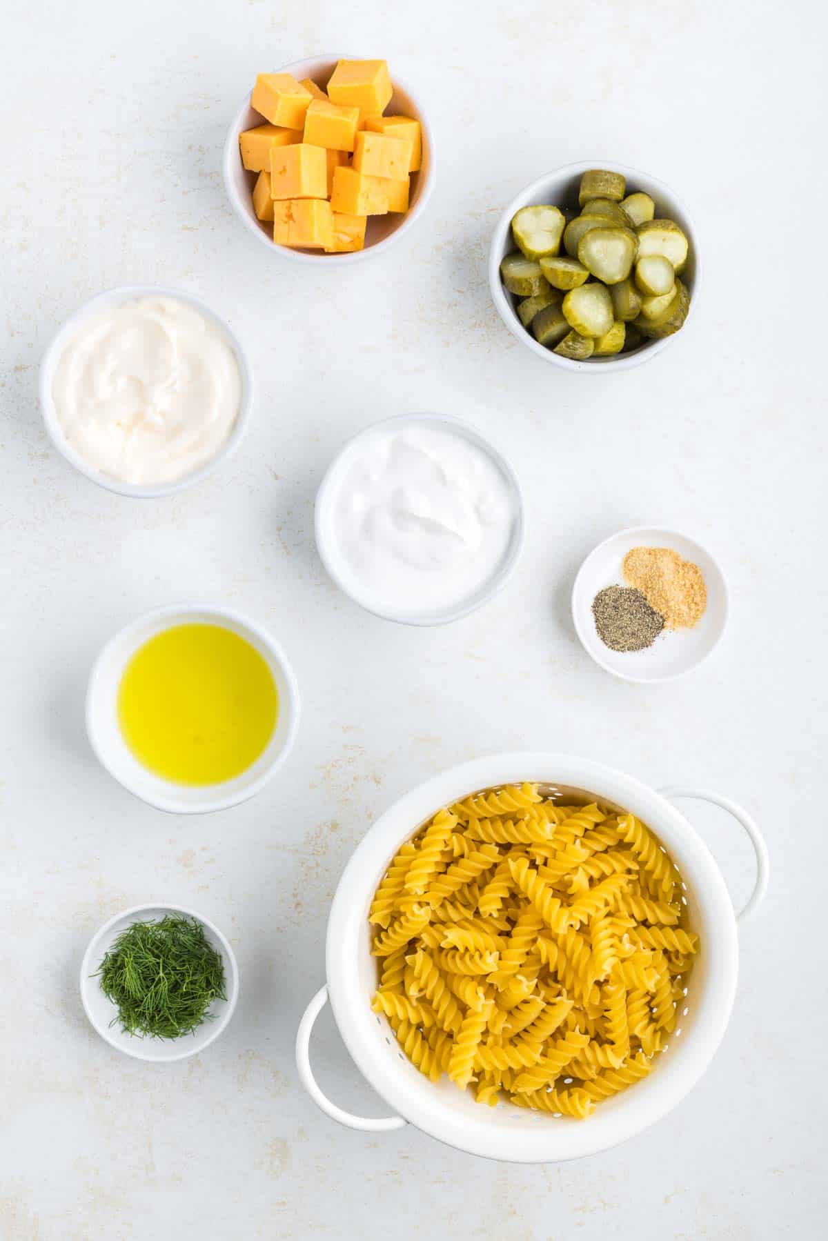 dill pickle pasta salad ingredients in prep bowls