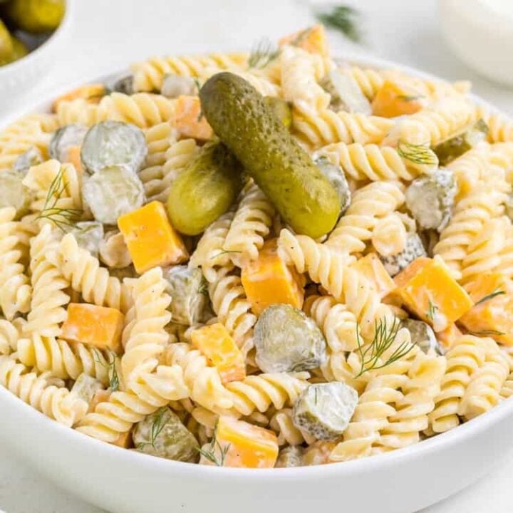 Dill Pickle Pasta Salad is a tasty cold side dish recipe made with rotini noodles and loaded with cheddar cheese, dill pickles and fresh dill all tossed in a mayo, sour cream and pickle juice dressing.