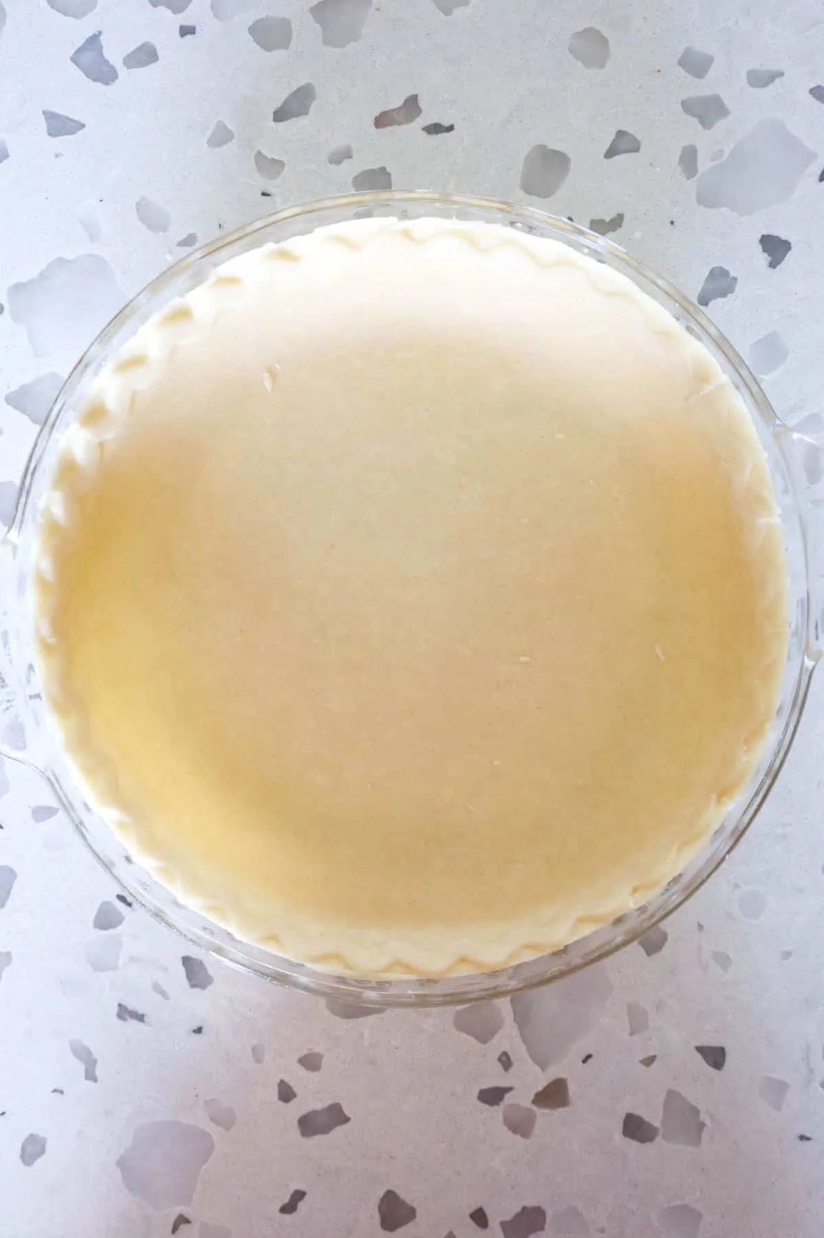unbaked pie shell in a glass pie plate