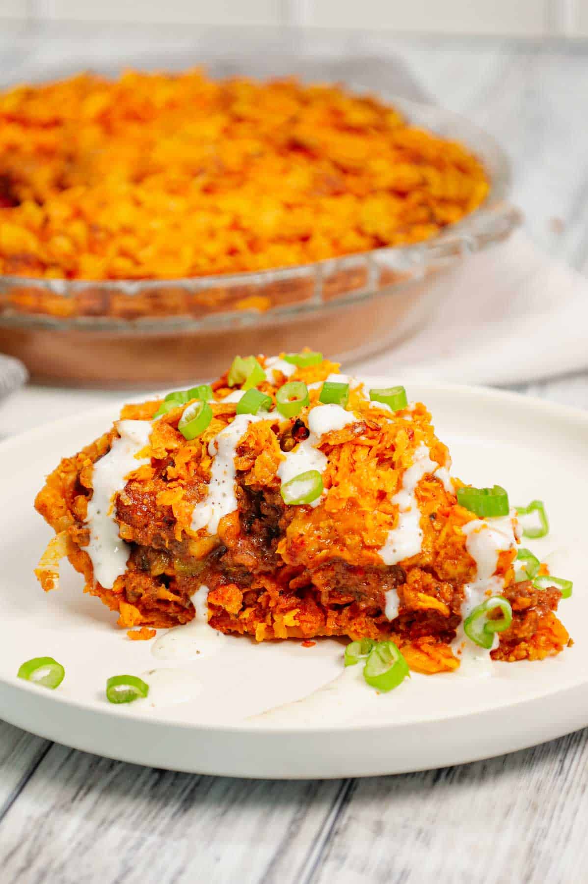 Dorito Taco Pie is an easy ground beef dinner recipe using a store bought deep dish pie crust loaded with crumbled Doritos nacho chips, beef taco meat, ranch dressing, salsa and shredded cheese.