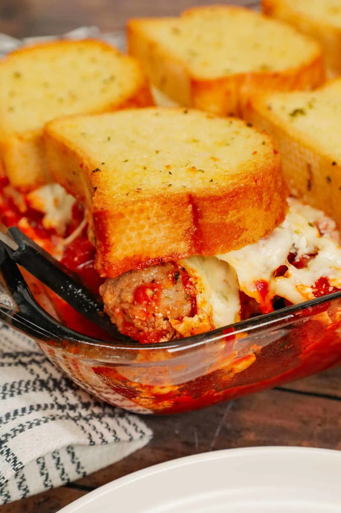 Dump and Bake Meatball Casserole is a hearty casserole made with frozen Italian meatballs, marinara sauce, diced tomatoes, ricotta and mozzarella and topped with frozen Texas toast garlic bread.