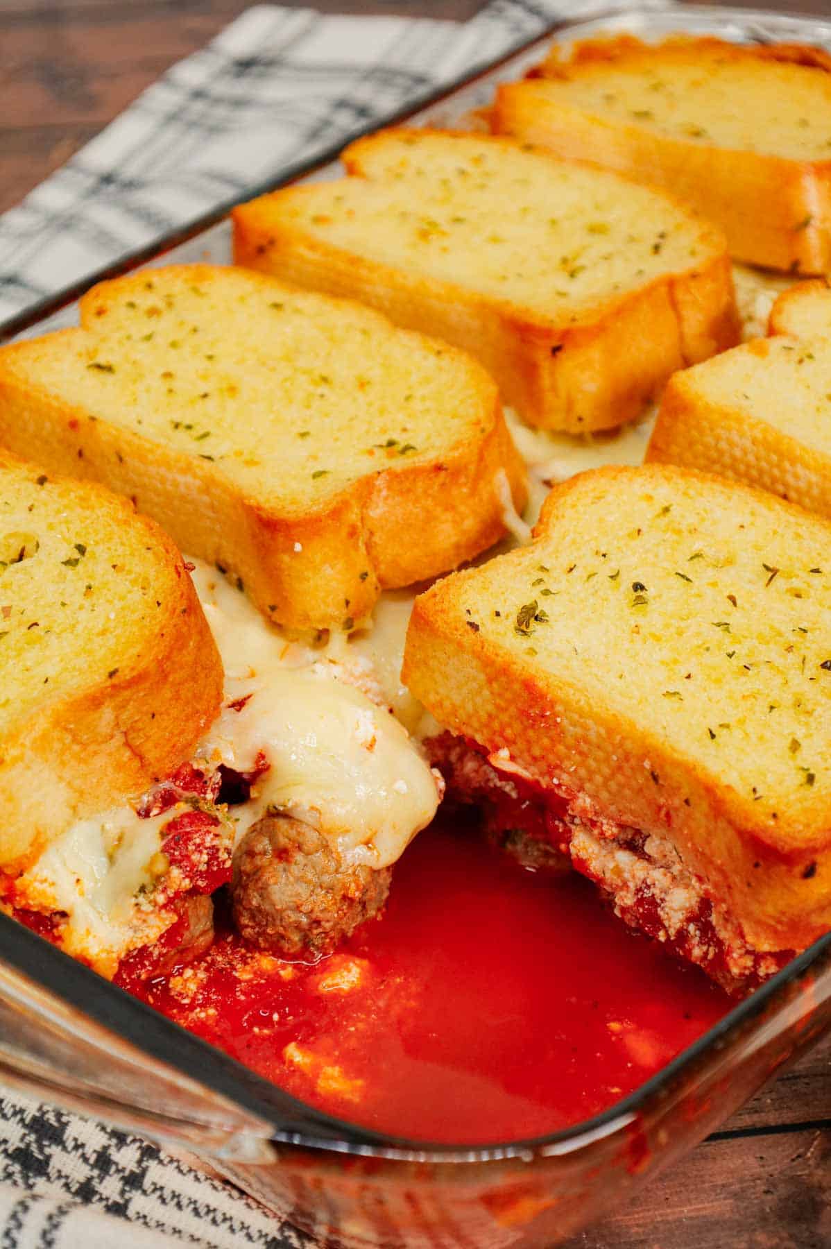 Dump and Bake Meatball Casserole is a hearty casserole made with frozen Italian meatballs, marinara sauce, diced tomatoes, ricotta and mozzarella and topped with frozen Texas toast garlic bread.