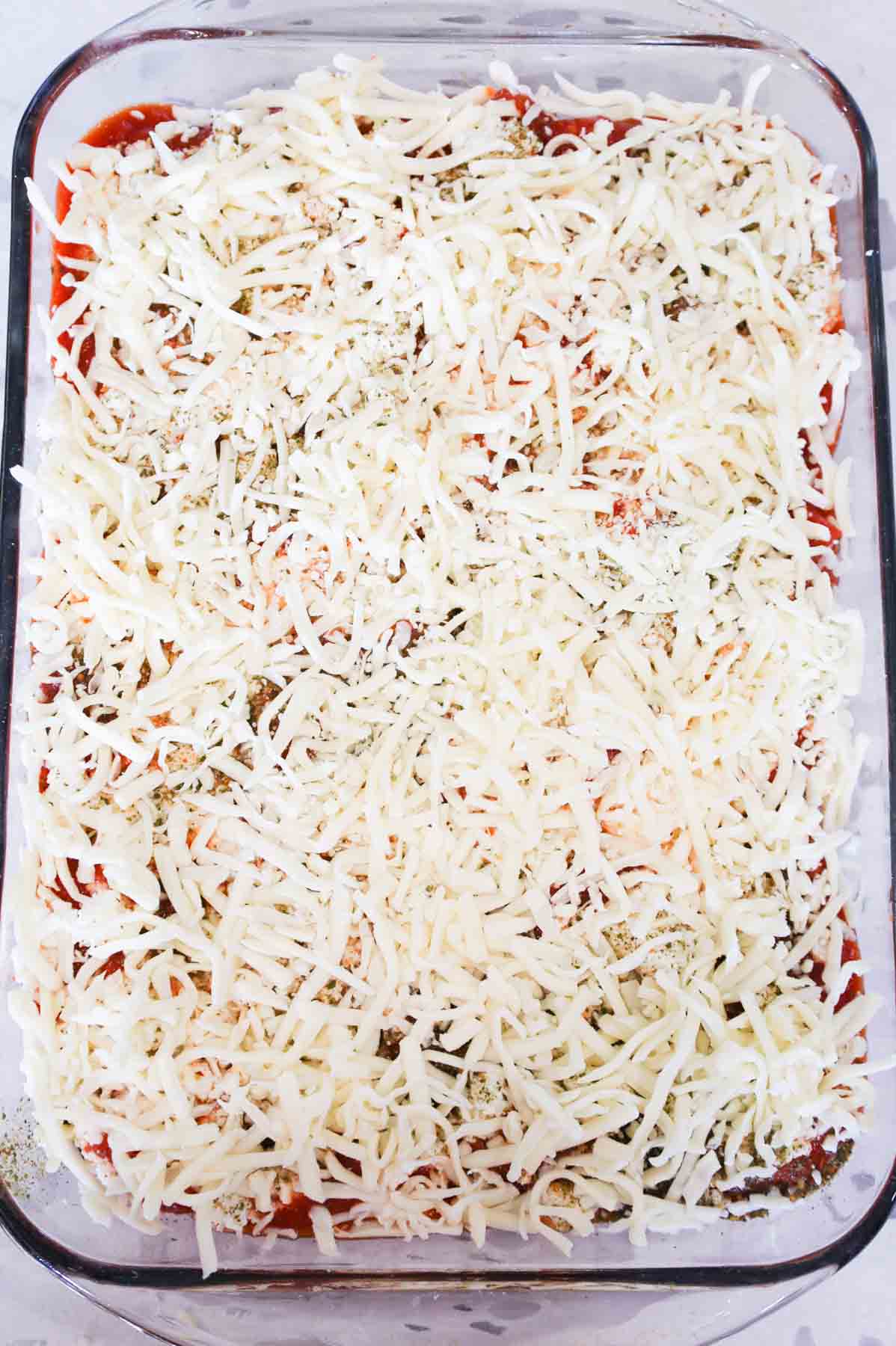 shredded mozzarella cheese on top of meatball casserole