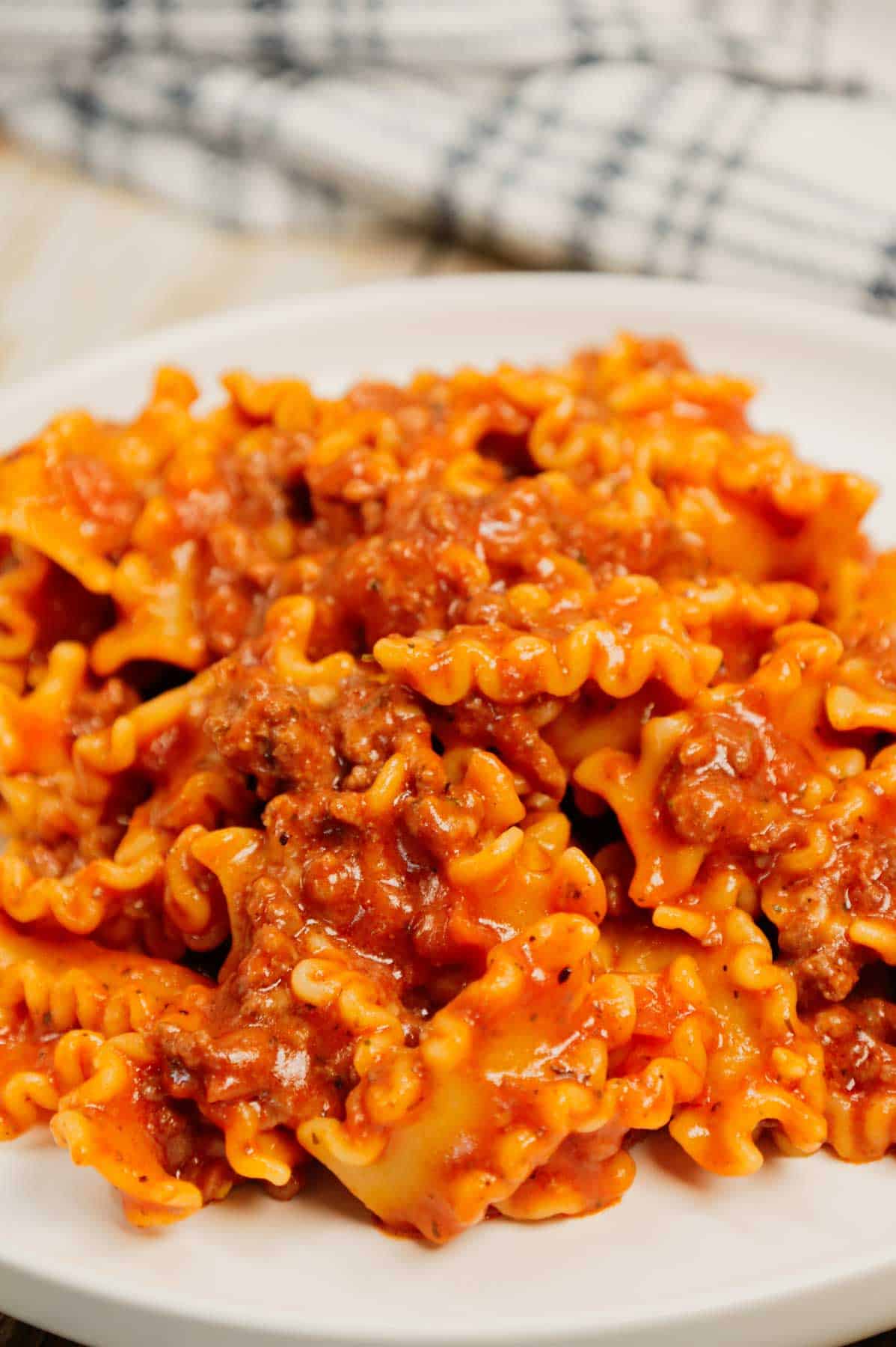 Hamburger Helper Lasagna is an easy ground beef dinner recipe using pasta that looks like mini lasagna noodles, tomato sauce, Italian seasoning, beef broth, shredded mozzarella and parmesan cheese.