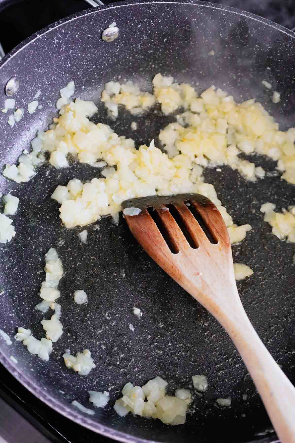 diced onions and garlic cooking in a skillet