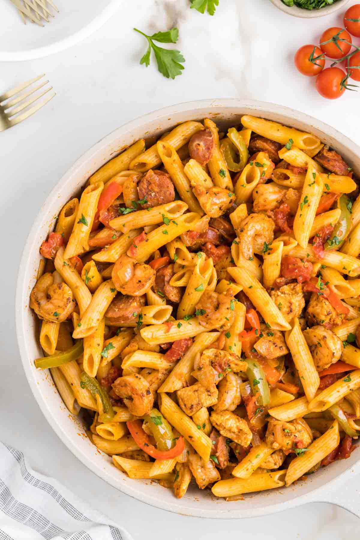 Jambalaya Pasta is a hearty penne pasta recipe loaded with bell peppers, shrimp, chicken breast chunks and andouille sausage all tossed in a tomato based sauce with a kick from some Cajun seasoning.