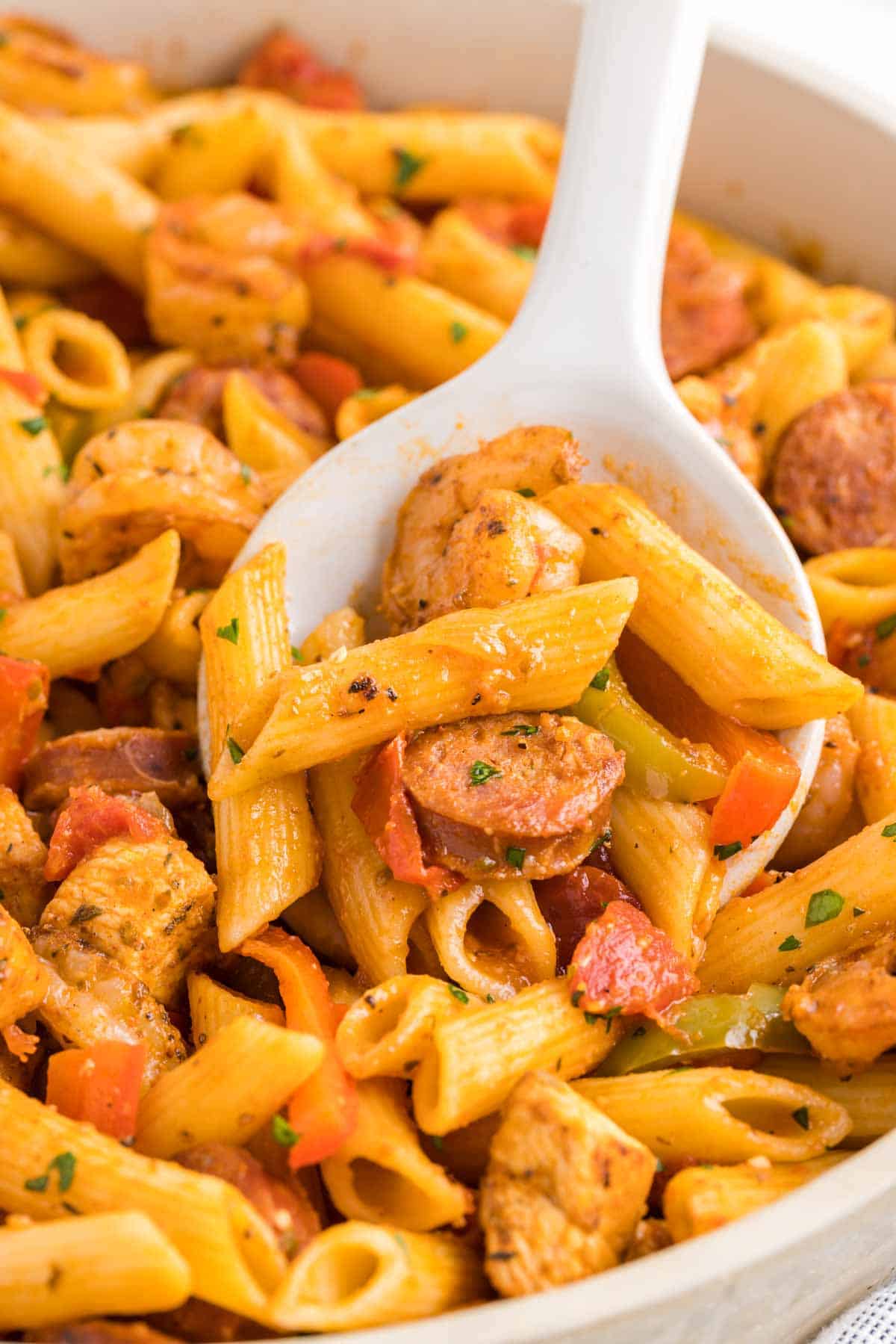 Jambalaya Pasta is a hearty penne pasta recipe loaded with bell peppers, shrimp, chicken breast chunks and andouille sausage all tossed in a tomato based sauce with a kick from some Cajun seasoning.