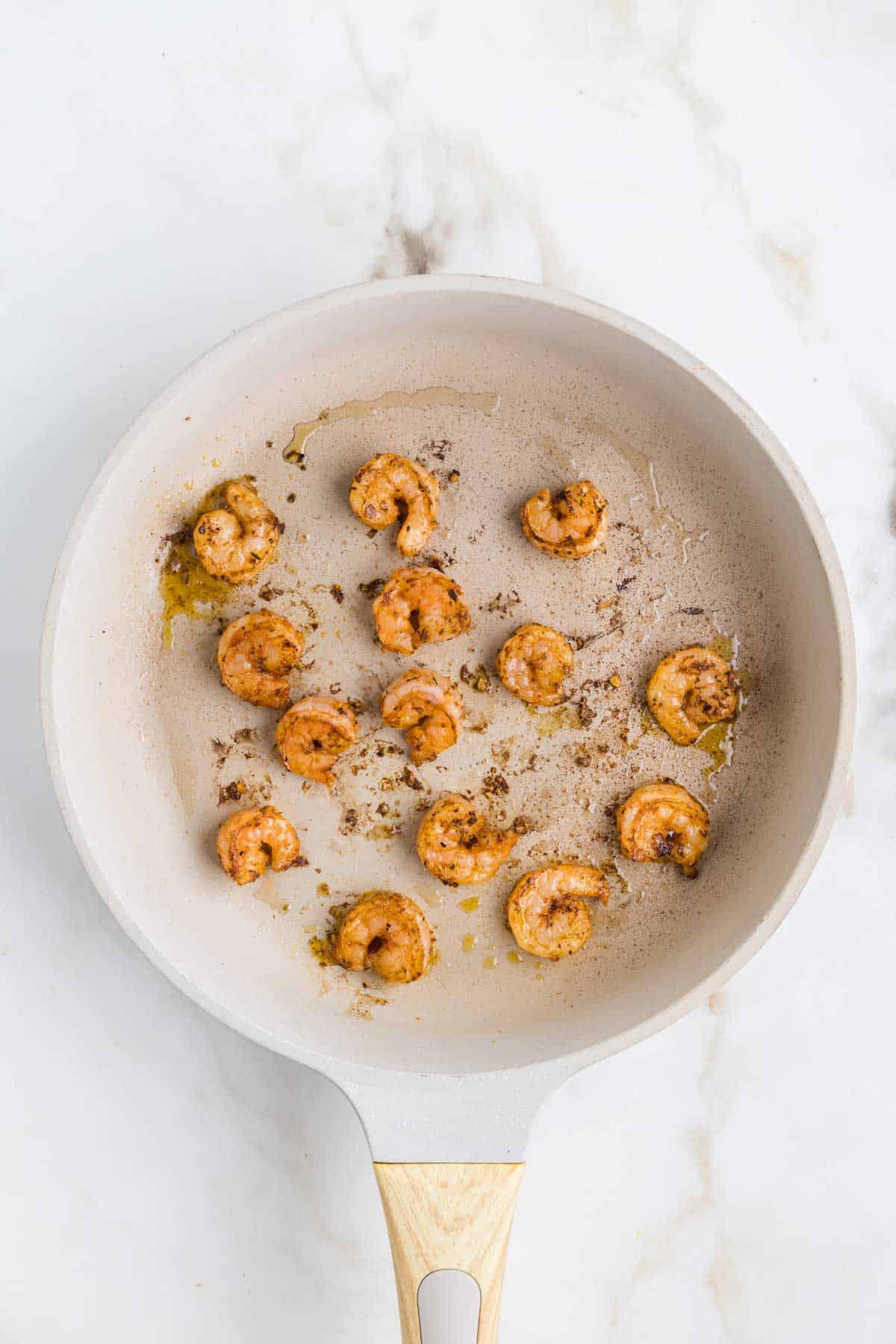 Cajun seasoned shrimp cooking in a skillet.