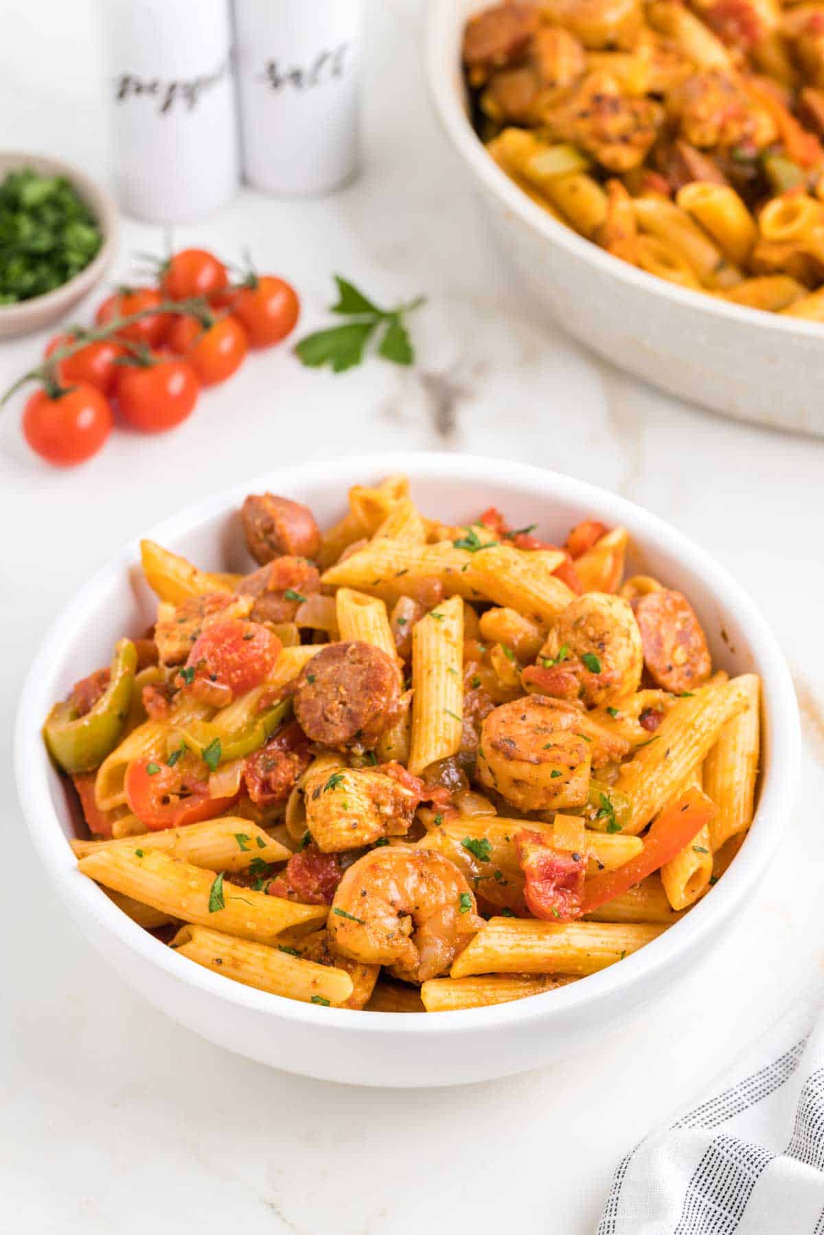 Jambalaya Pasta is a hearty penne pasta recipe loaded with bell peppers, shrimp, chicken breast chunks and andouille sausage all tossed in a tomato based sauce with a kick from some Cajun seasoning.