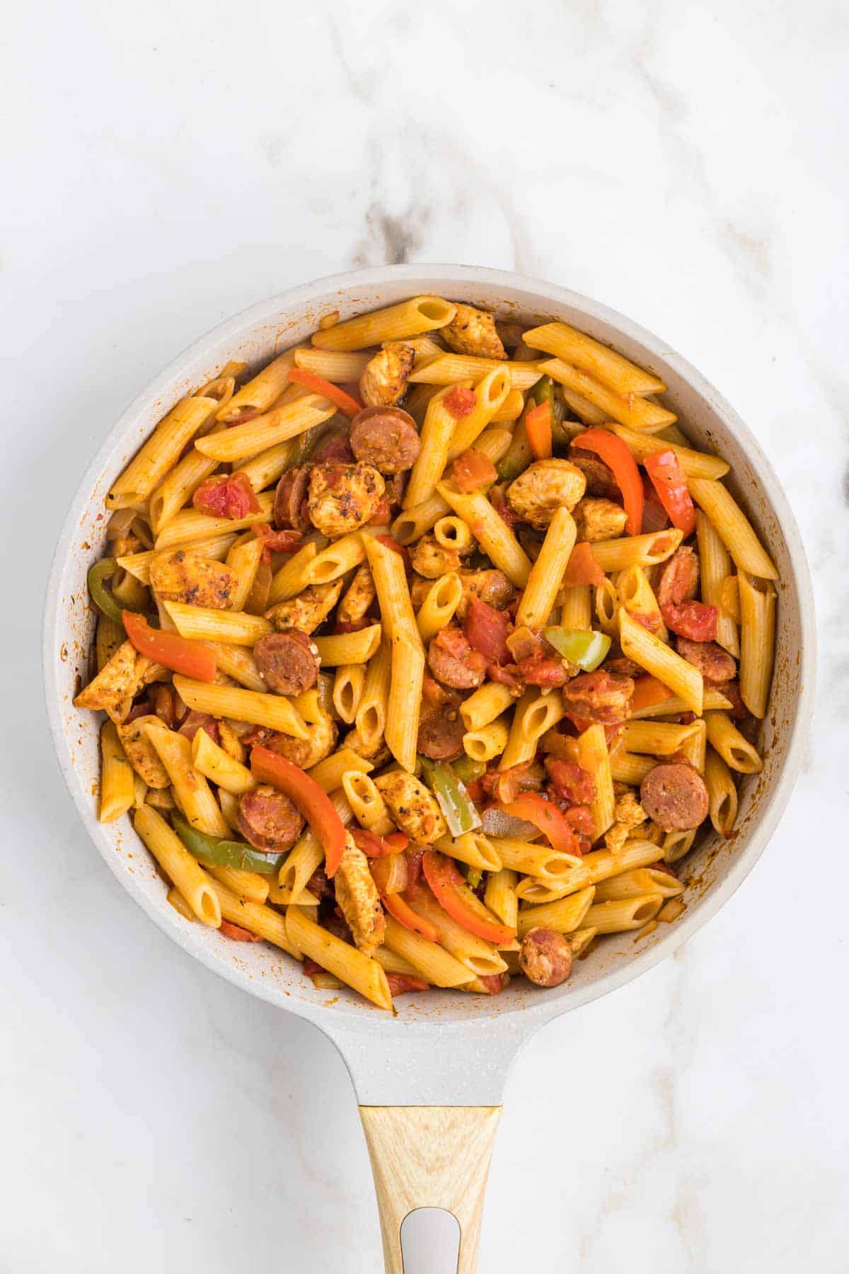 Jambalaya Pasta is a hearty penne pasta recipe loaded with bell peppers, shrimp, chicken breast chunks and andouille sausage all tossed in a tomato based sauce with a kick from some Cajun seasoning.