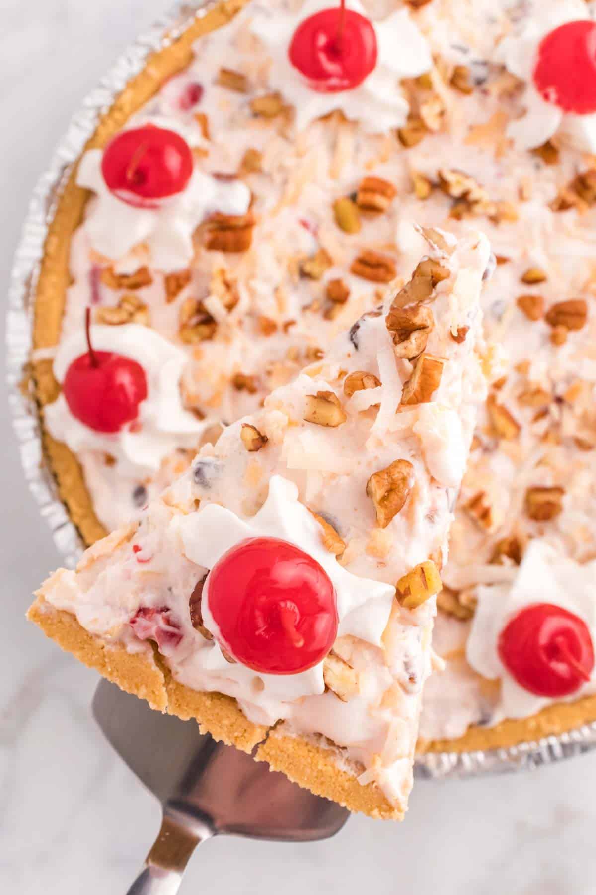 Million Dollar Pie is a creamy no bake pie loaded with crushed pineapple, chopped pecans, toasted coconut, maraschino cherries, mini marshmallows and chocolate chips all in a graham cracker crust.