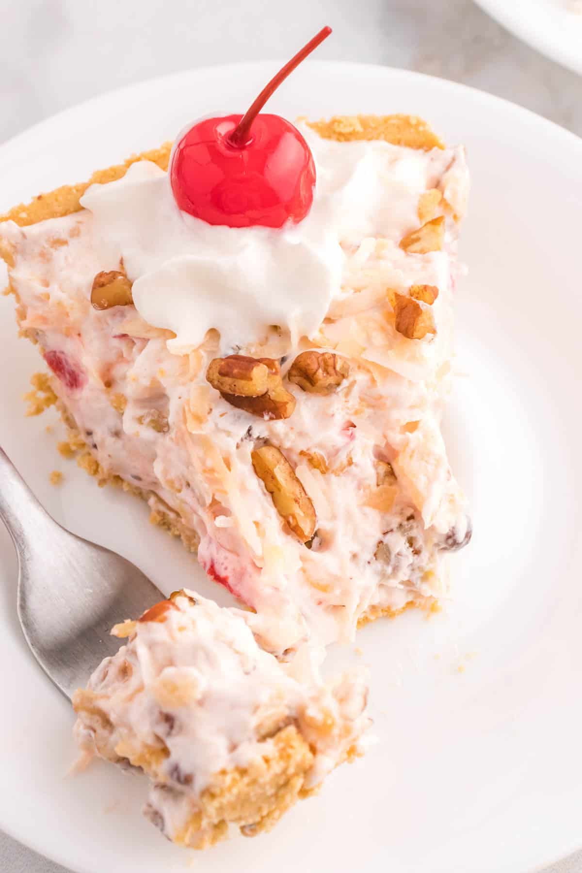 Million Dollar Pie is a creamy no bake pie loaded with crushed pineapple, chopped pecans, toasted coconut, maraschino cherries, mini marshmallows and chocolate chips all in a graham cracker crust.