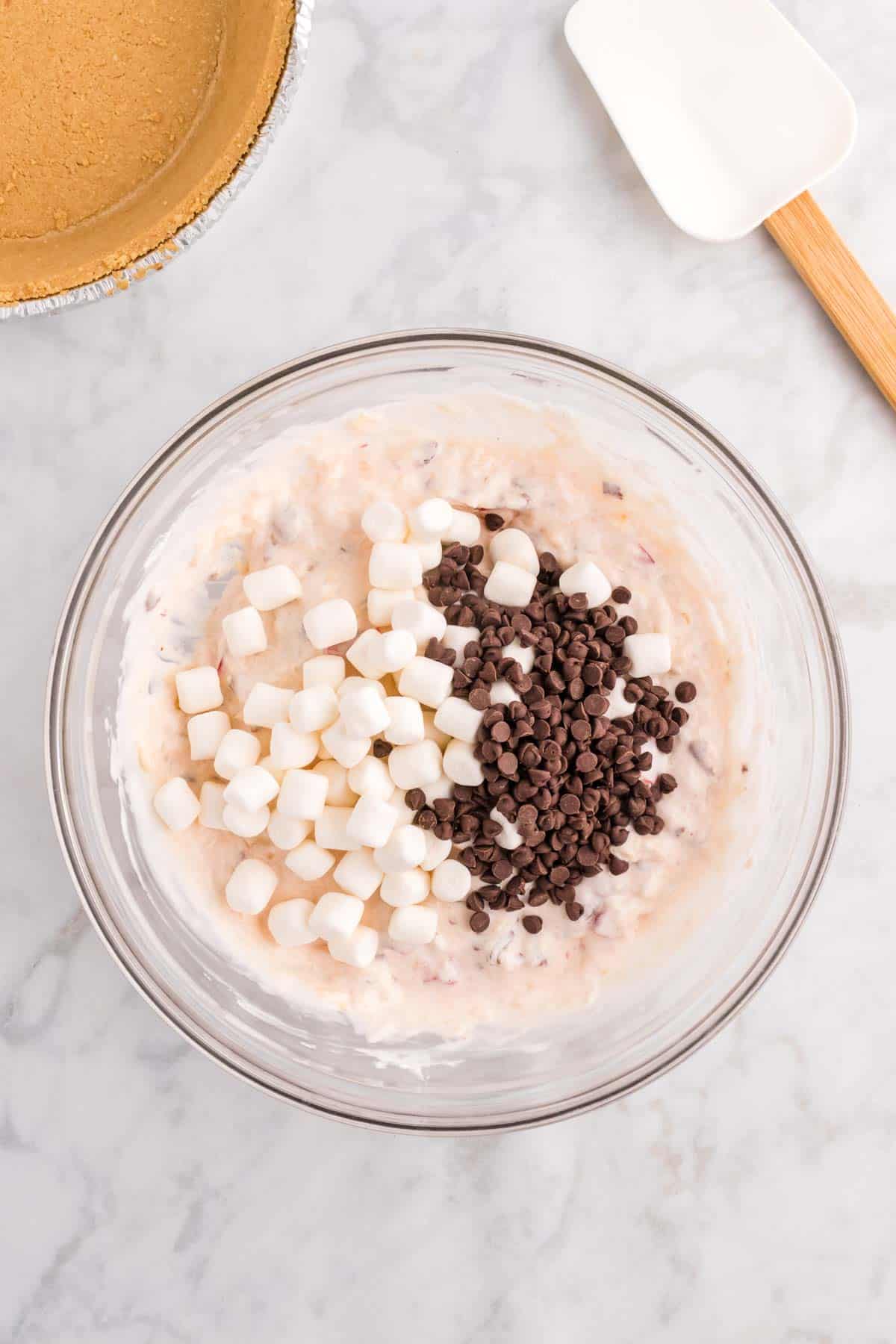 mini marshmallows and mini chocolate chips on top of creamy mixture in a bowl