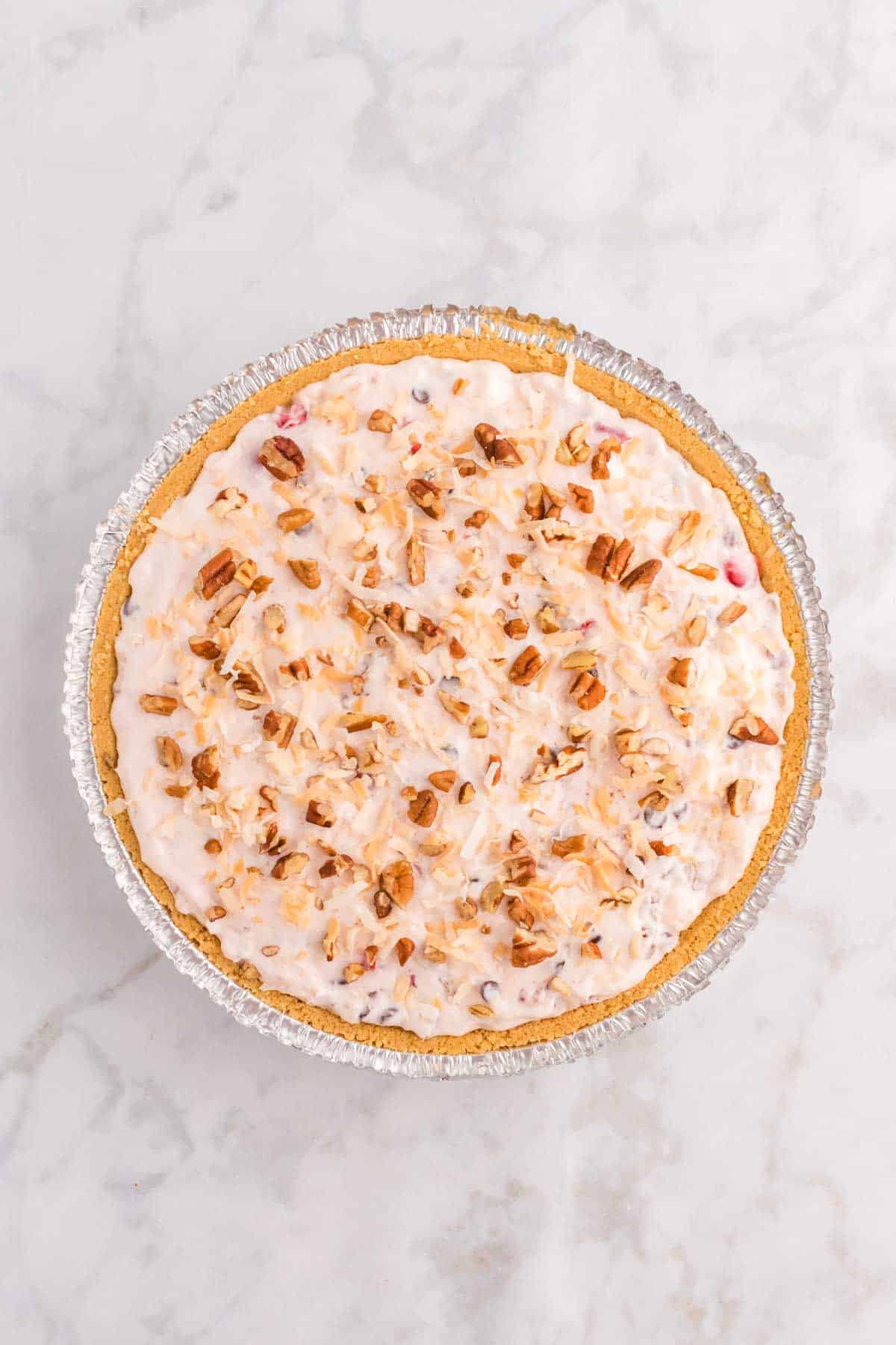toasted coconut and chopped pecans on top of no bake pie