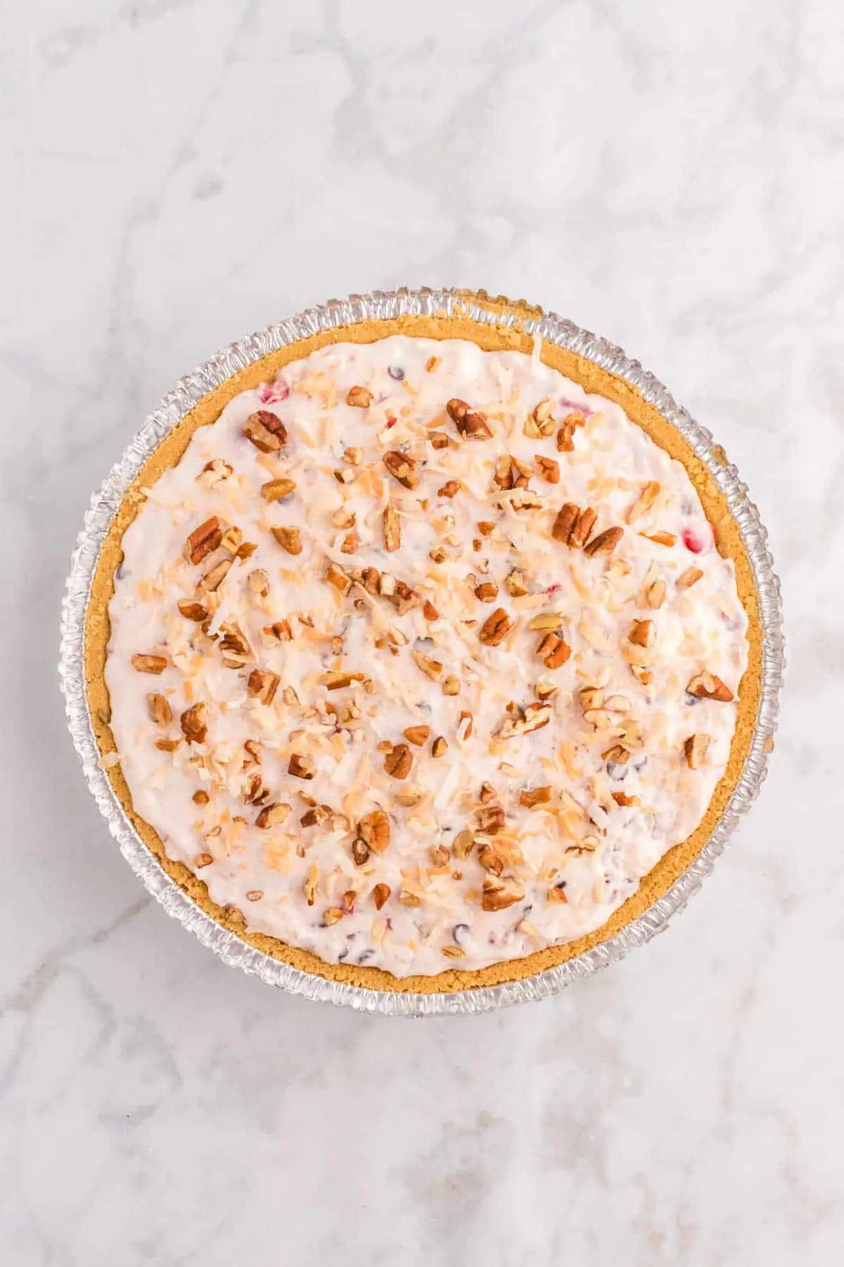 toasted coconut and chopped pecans on top of no bake pie