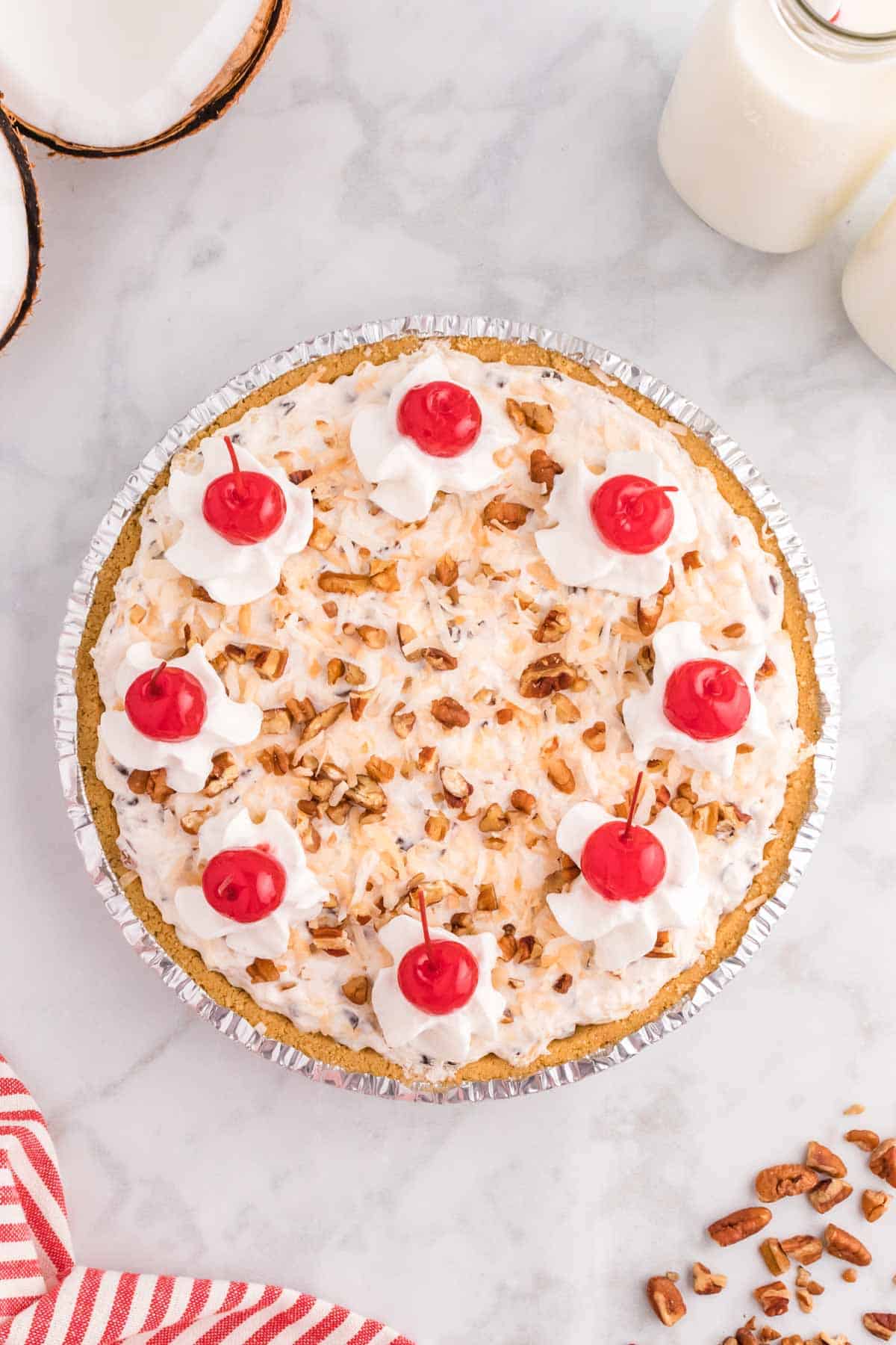 Million Dollar Pie is a creamy no bake pie loaded with crushed pineapple, chopped pecans, toasted coconut, maraschino cherries, mini marshmallows and chocolate chips all in a graham cracker crust.