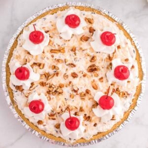 Million Dollar Pie is a creamy no bake pie loaded with crushed pineapple, chopped pecans, toasted coconut, maraschino cherries, mini marshmallows and chocolate chips all in a graham cracker crust.