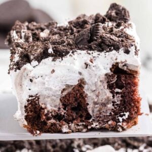 Oreo Poke Cake is a a simple but decadent cake recipe made with boxed chocolate cake mix, Oreo cookies n' creme pudding mix, milk, Cool Whip and Oreo cookies.