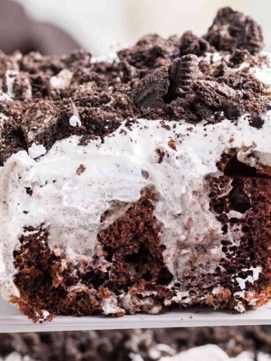 Oreo Poke Cake is a a simple but decadent cake recipe made with boxed chocolate cake mix, Oreo cookies n' creme pudding mix, milk, Cool Whip and Oreo cookies.