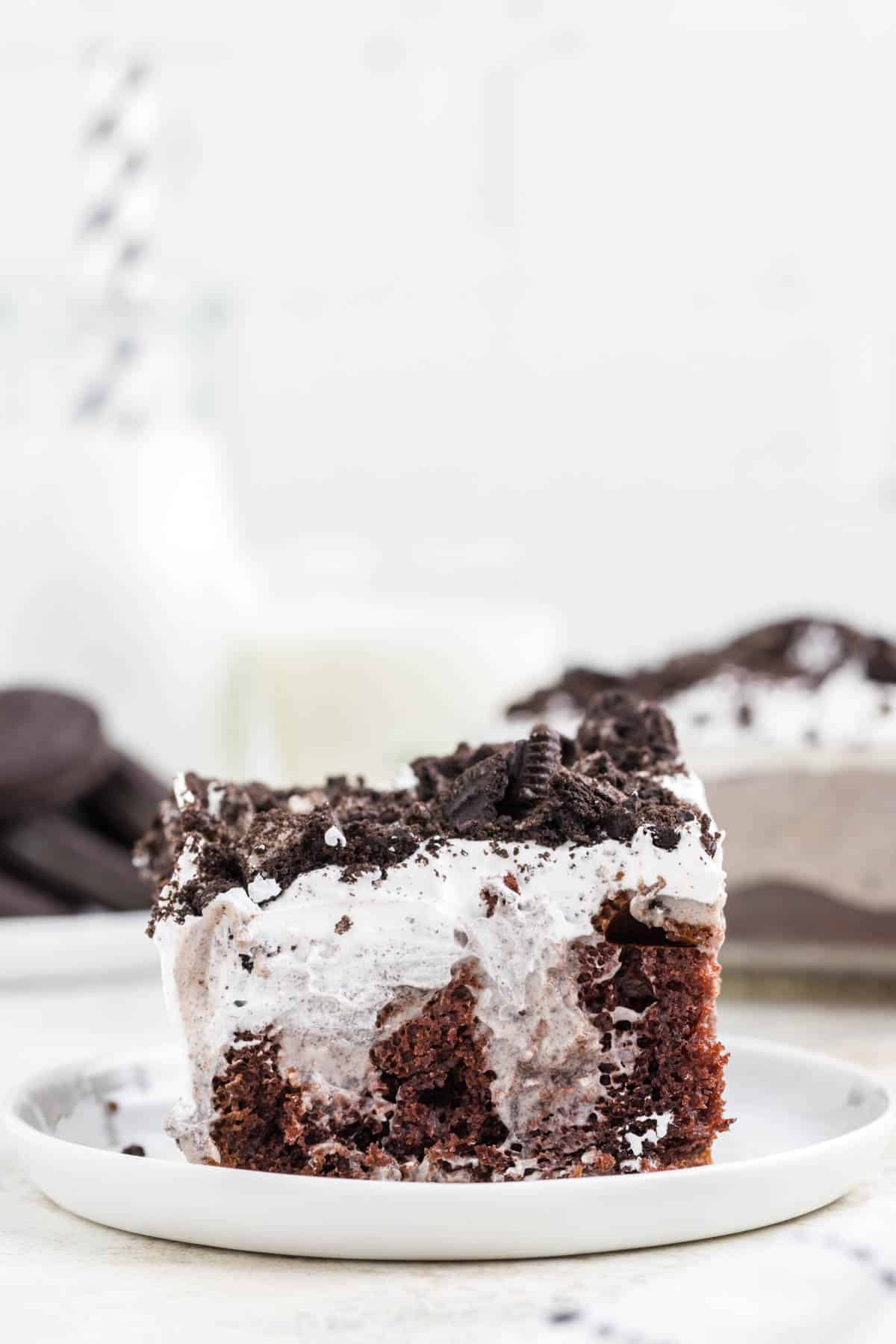Oreo Poke Cake is a a simple but decadent cake recipe made with boxed chocolate cake mix, Oreo cookies n' creme pudding mix, milk, Cool Whip and Oreo cookies.