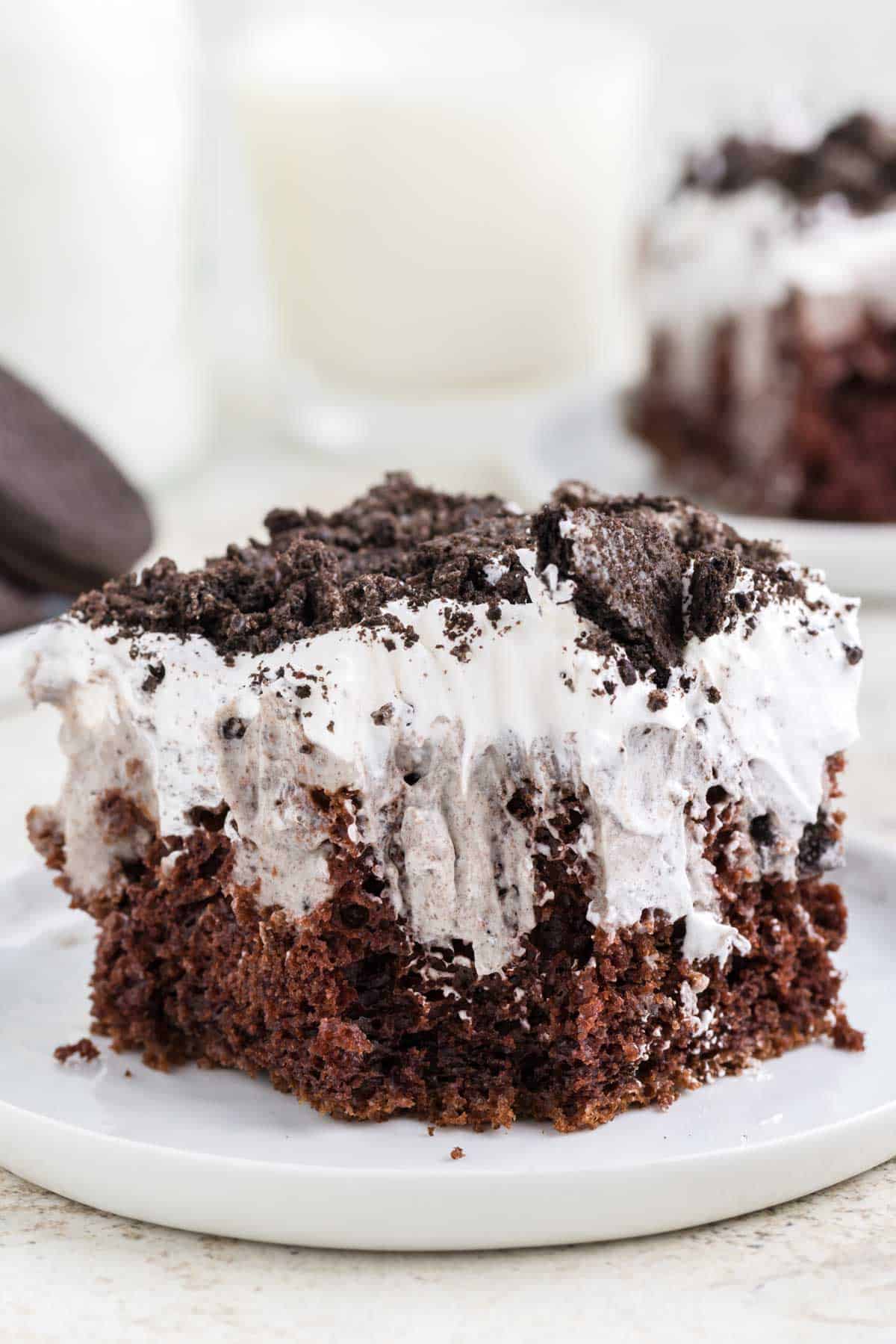 Oreo Poke Cake is a a simple but decadent cake recipe made with boxed chocolate cake mix, Oreo cookies n' creme pudding mix, milk, Cool Whip and Oreo cookies.