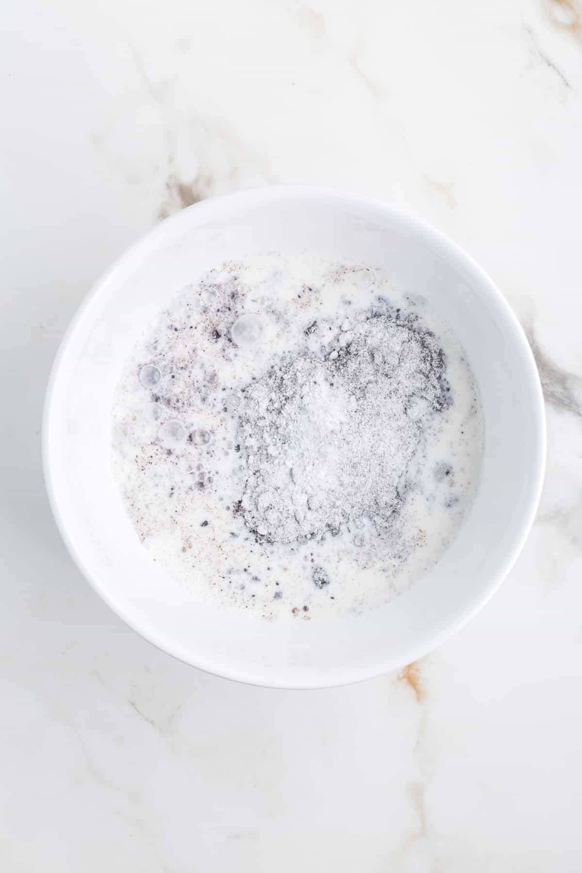 milk and Oreo pudding mix in a mixing bowl