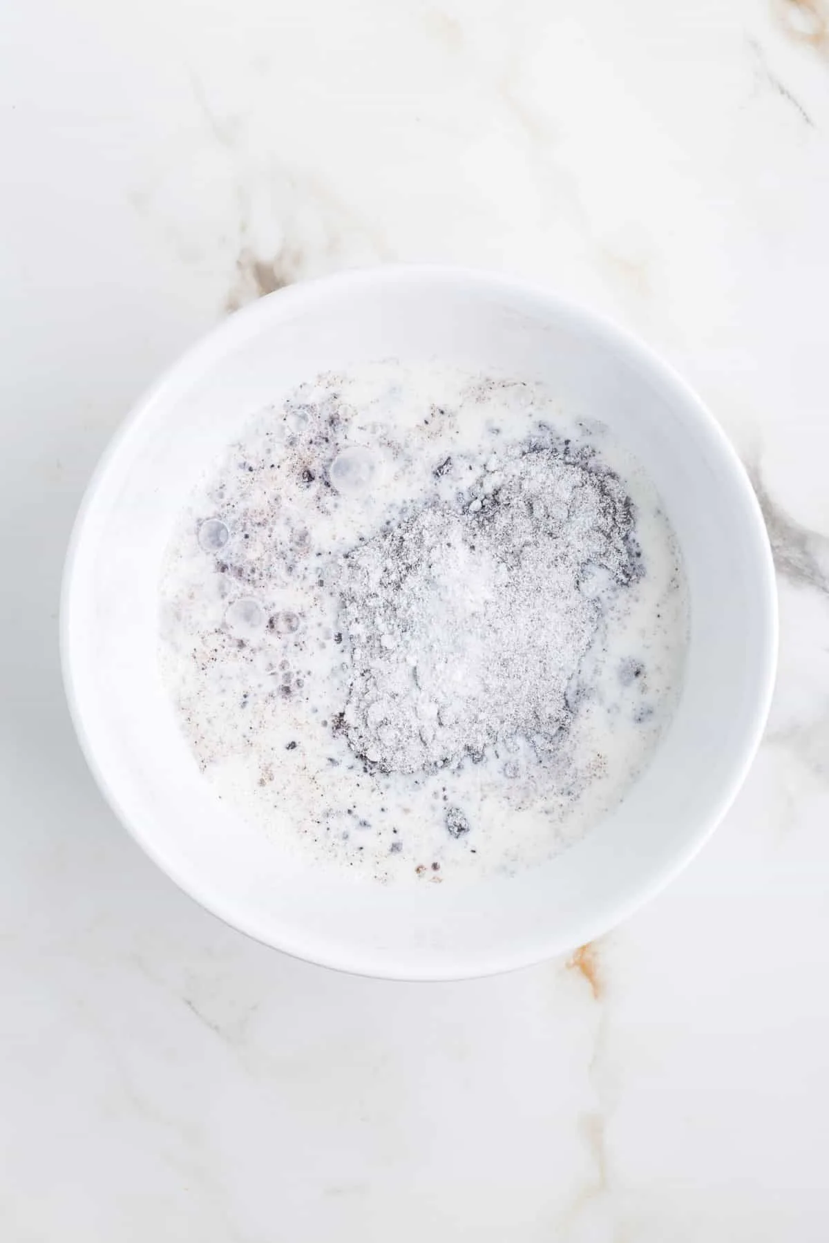 milk and Oreo pudding mix in a mixing bowl