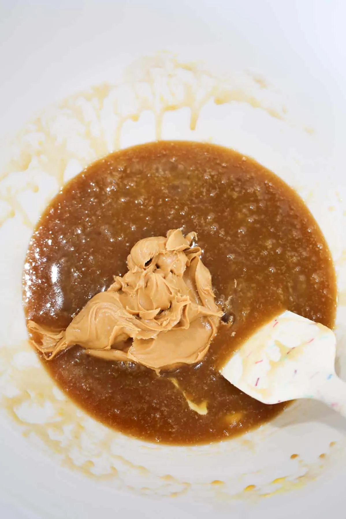 peanut butter added to mixing bowl with melted butter, brown sugar and egg mixture