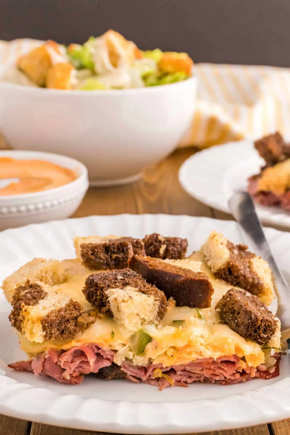 Reuben Casserole is a tasty dish loaded with cubes of rye bread, sliced corned beef, sauerkraut, dill pickles, Swiss cheese and Thousand Island dressing.