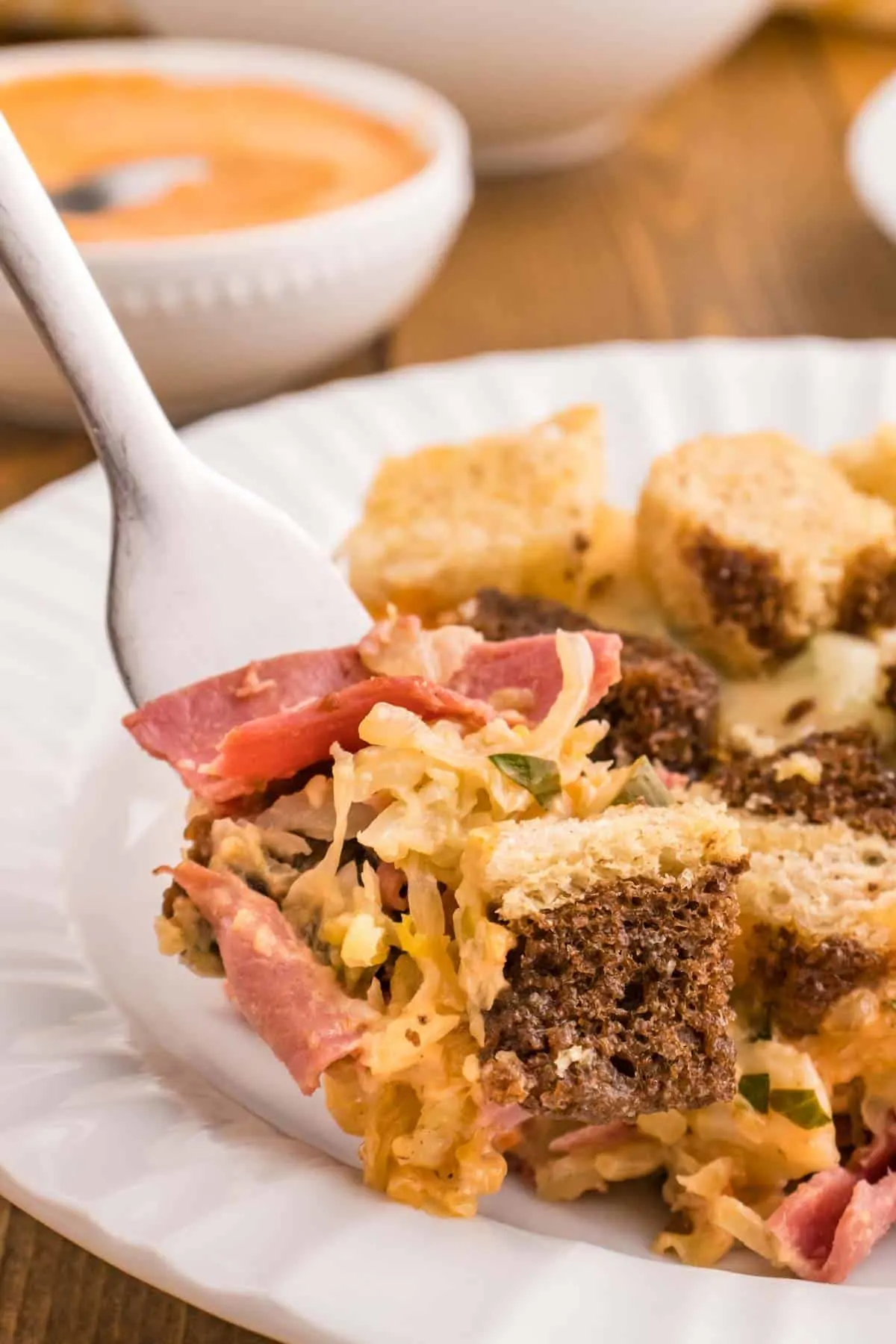 Reuben Casserole is a tasty dish loaded with cubes of rye bread, sliced corned beef, sauerkraut, dill pickles, Swiss cheese and Thousand Island dressing.