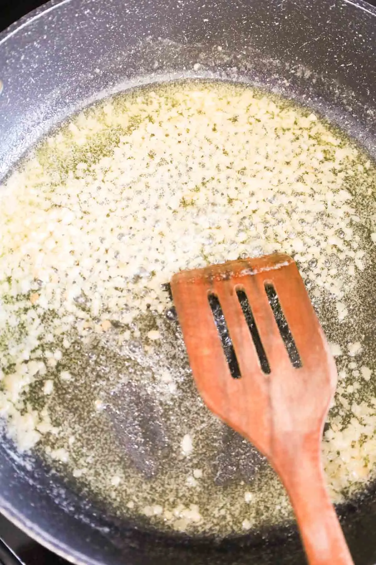 stirring minced garlic and melted butter in a skillet