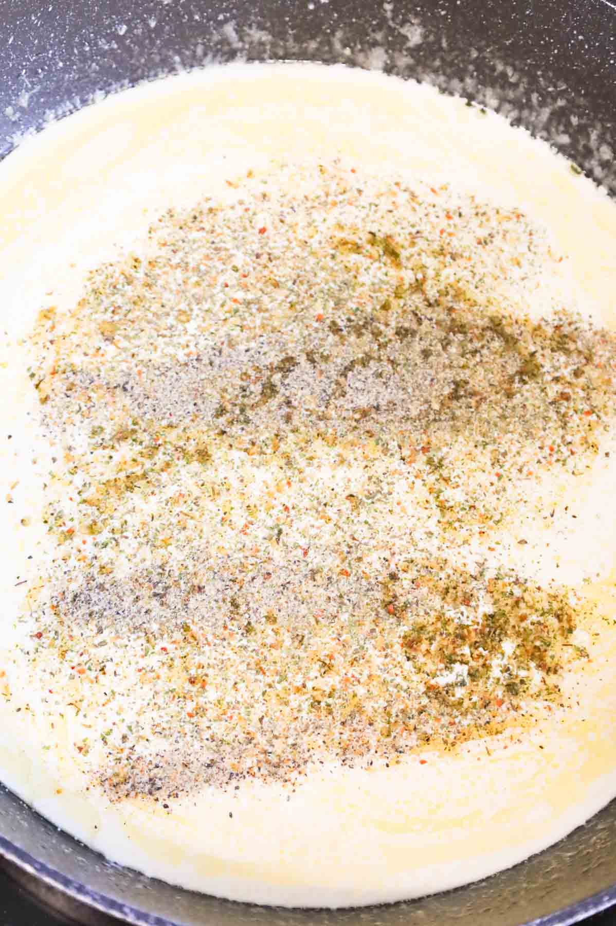 Italian seasoning, salt and pepper added to skillet with heavy cream