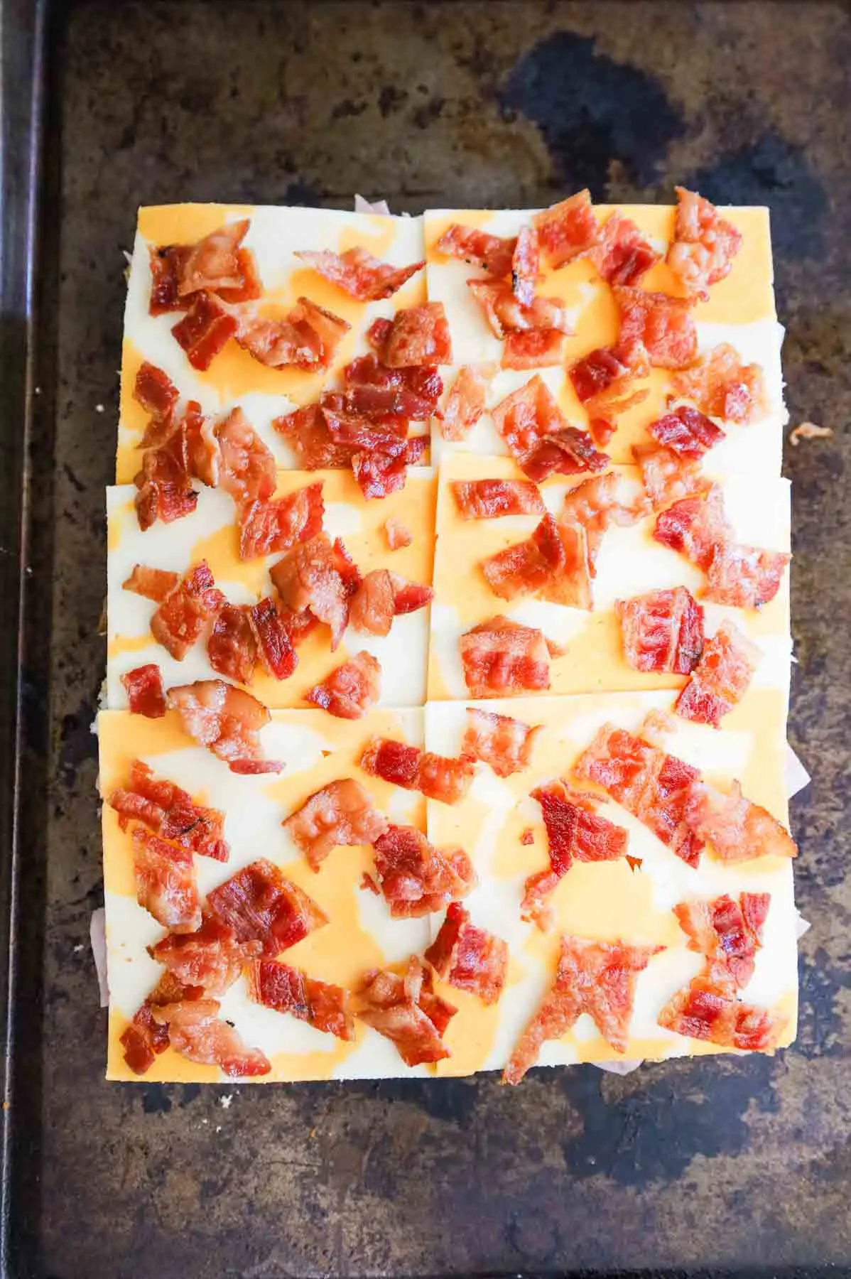 chopped bacon on top of cheddar cheese slices