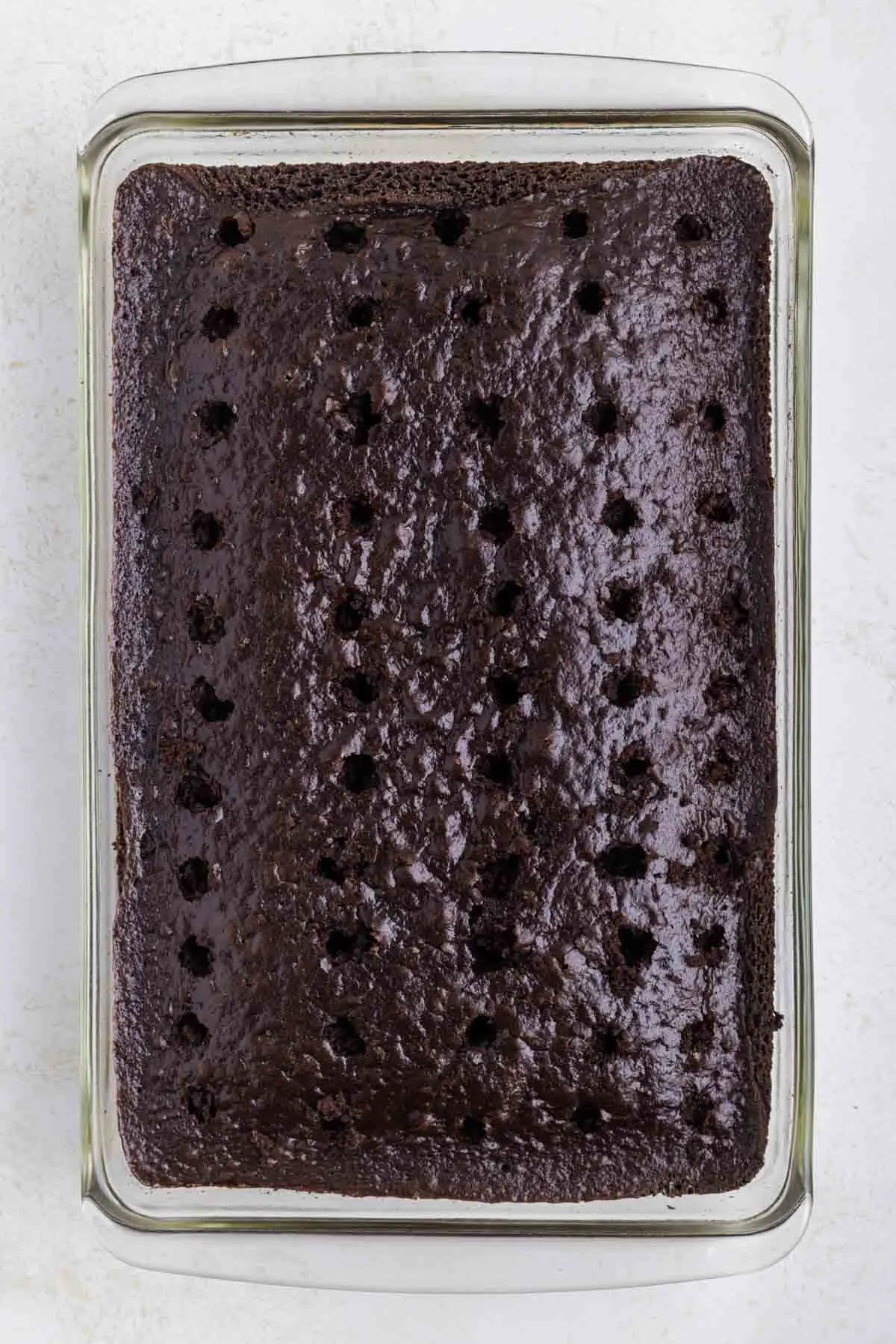 holes poked in chocolate cake in pan
