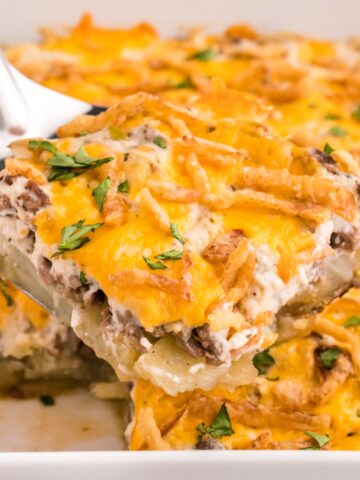 Hobo Casserole is a layered ground beef and sliced potato casserole loaded with diced bell peppers, onions, sour cream, cream of mushroom soup, cheddar cheese and French's crispy fried onions.