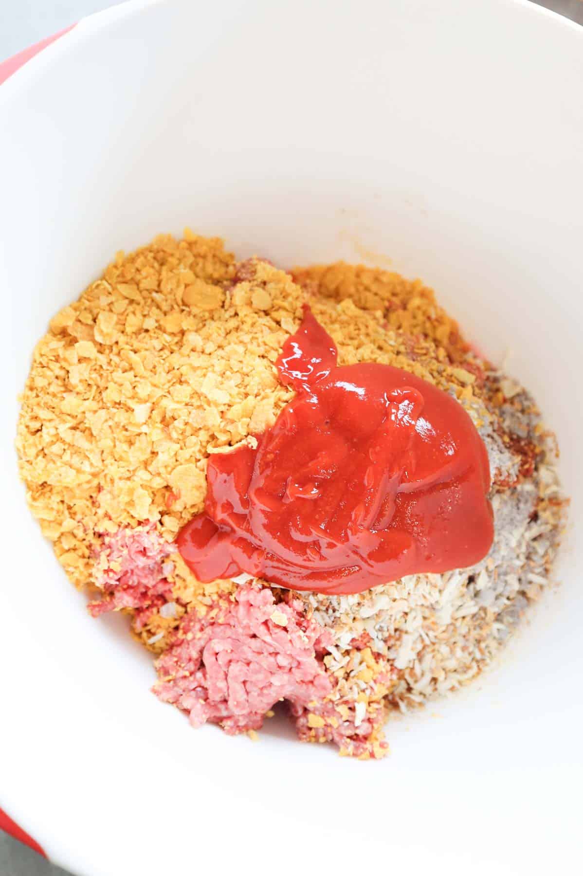 ketchup glaze, crushed cornflakes, onion soup mix and ground beef in a mixing bowl