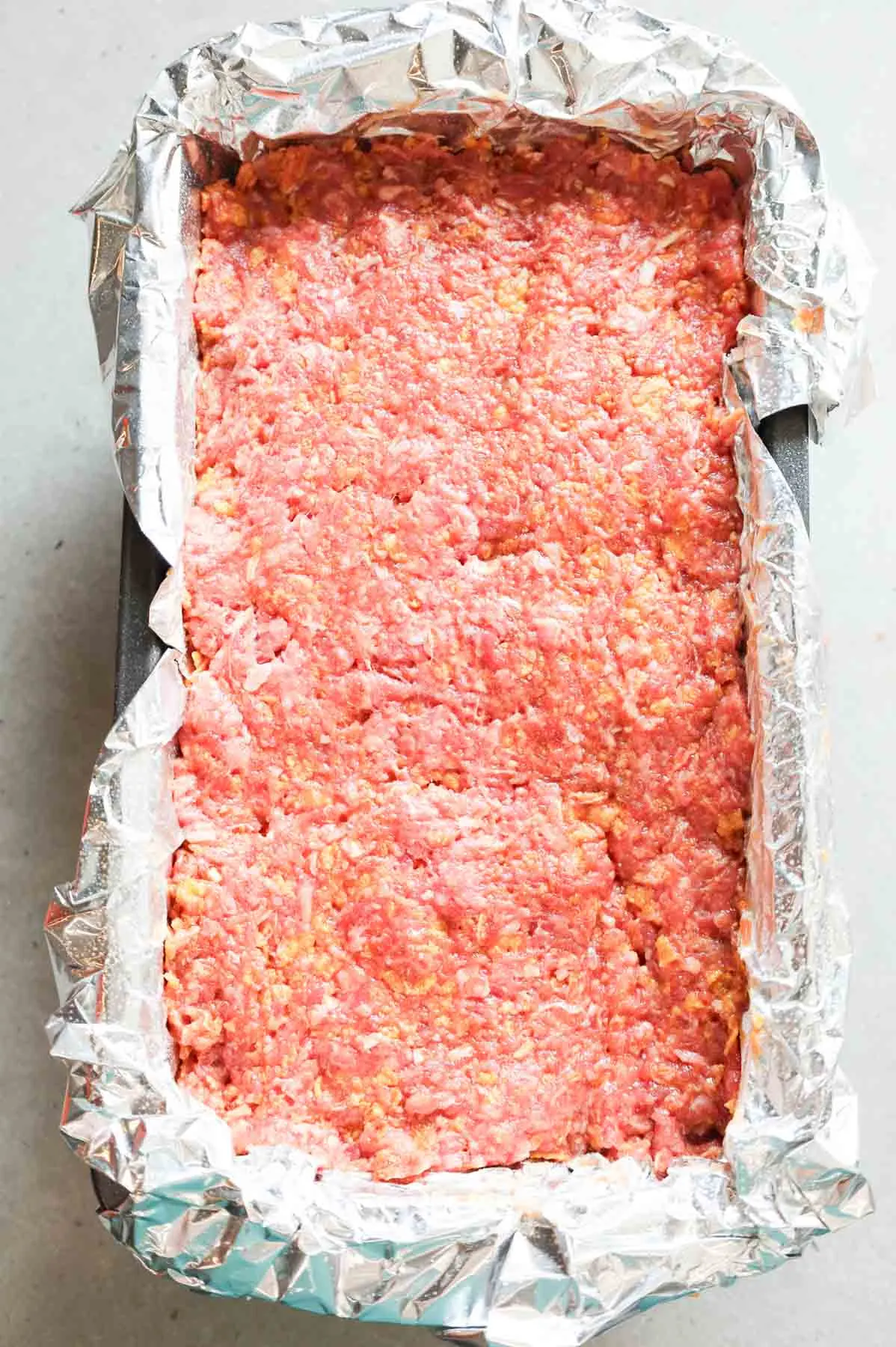 meatloaf mixture in a foil lined loaf pan