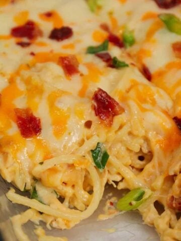 Crack Chicken Spaghetti is a delicious baked pasta recipe with a creamy sauce and loaded with shredded chicken, crumbled bacon, chopped green onions, ranch dressing mix and shredded cheddar and mozzarella cheese.