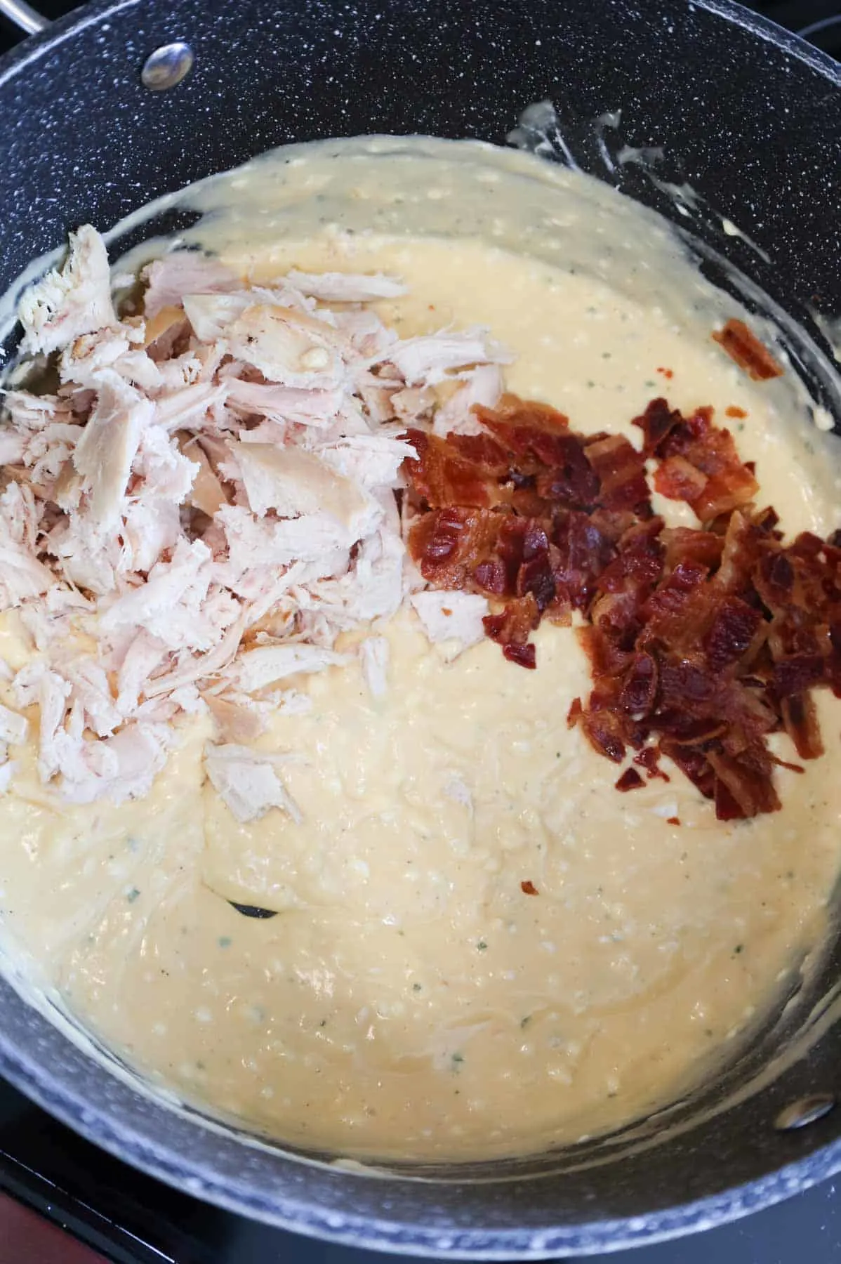 shredded chicken and crumbled bacon added to pot with cream sauce