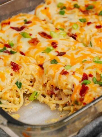 Crack Chicken Spaghetti is a delicious baked pasta recipe with a creamy sauce and loaded with shredded chicken, crumbled bacon, chopped green onions, ranch dressing mix and shredded cheddar and mozzarella cheese.