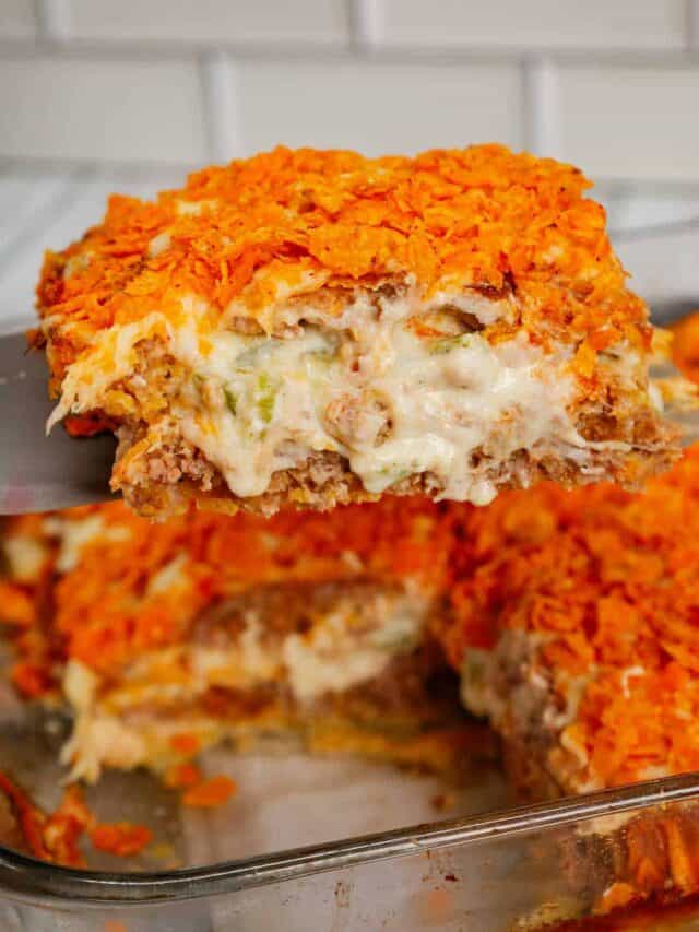 Dorito Meatloaf Casserole is a hearty dish with layers of ground beef and sausage meatloaf loaded with crushed Doritos, a cream cheese and ranch dressing filling and topped with cheese and more crushed Doritos.