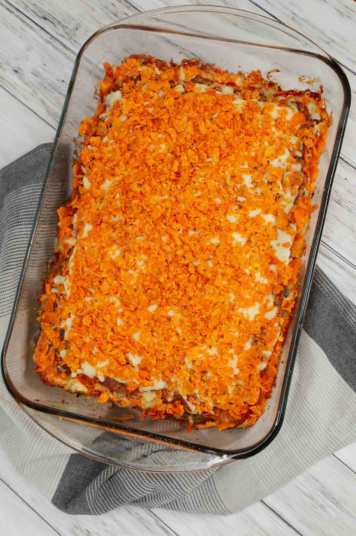 Dorito Meatloaf Casserole is a hearty dish with layers of ground beef and sausage meatloaf loaded with crushed Doritos, a cream cheese and ranch dressing filling and topped with cheese and more crushed Doritos.