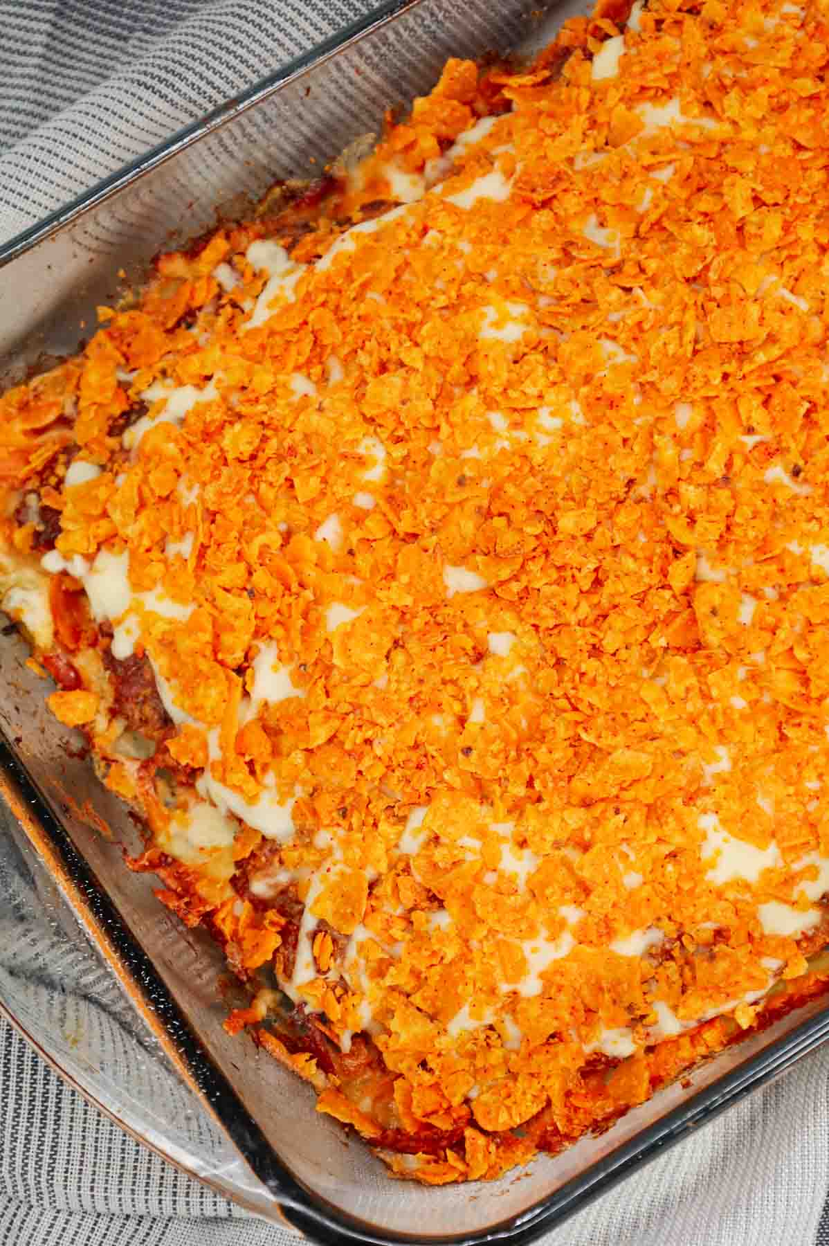 Dorito Meatloaf Casserole is a hearty dish with layers of ground beef and sausage meatloaf loaded with crushed Doritos, a cream cheese and ranch dressing filling and topped with cheese and more crushed Doritos.