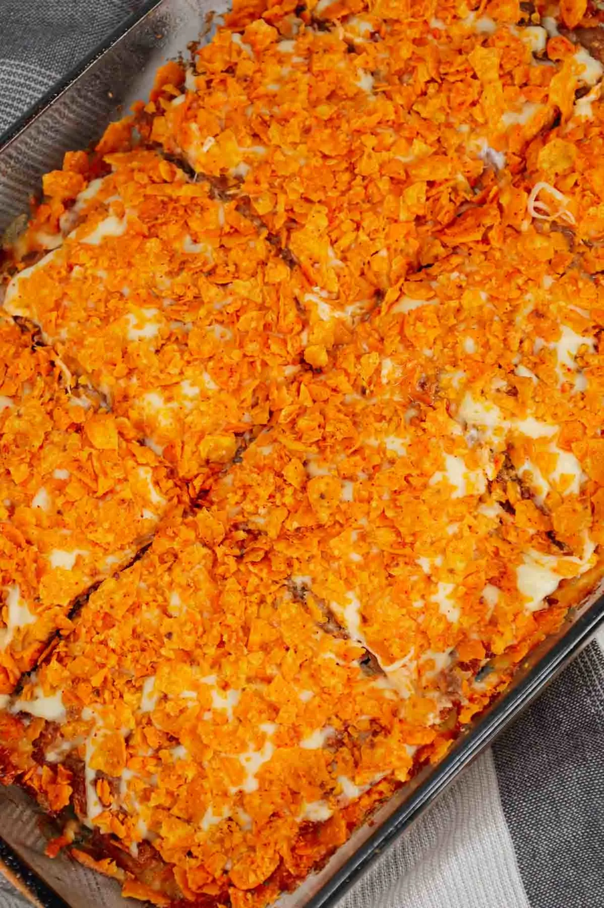 Dorito Meatloaf Casserole is a hearty dish with layers of ground beef and sausage meatloaf loaded with crushed Doritos, a cream cheese and ranch dressing filling and topped with cheese and more crushed Doritos.