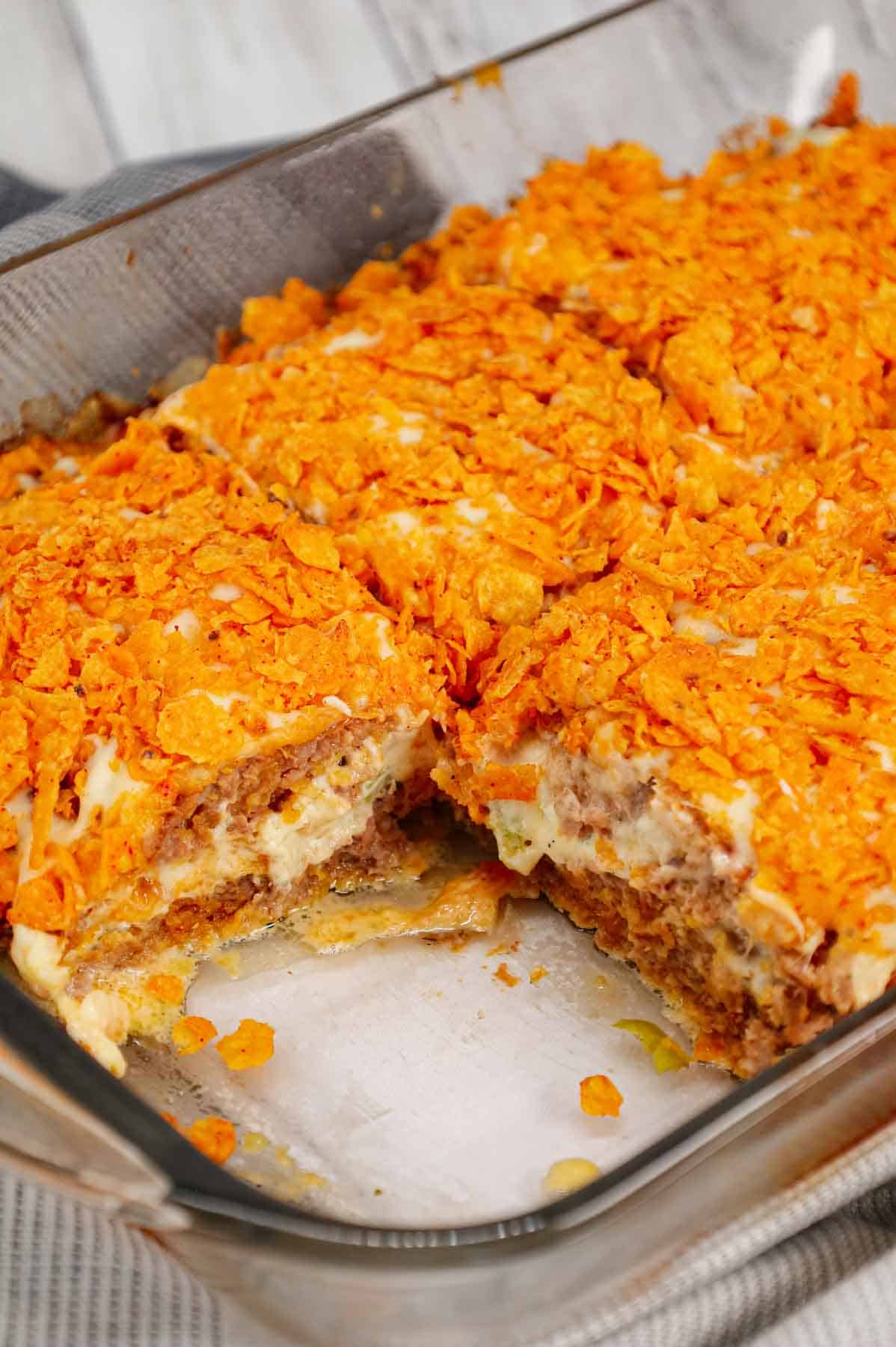 Dorito Meatloaf Casserole is a hearty dish with layers of ground beef and sausage meatloaf loaded with crushed Doritos, a cream cheese and ranch dressing filling and topped with cheese and more crushed Doritos.