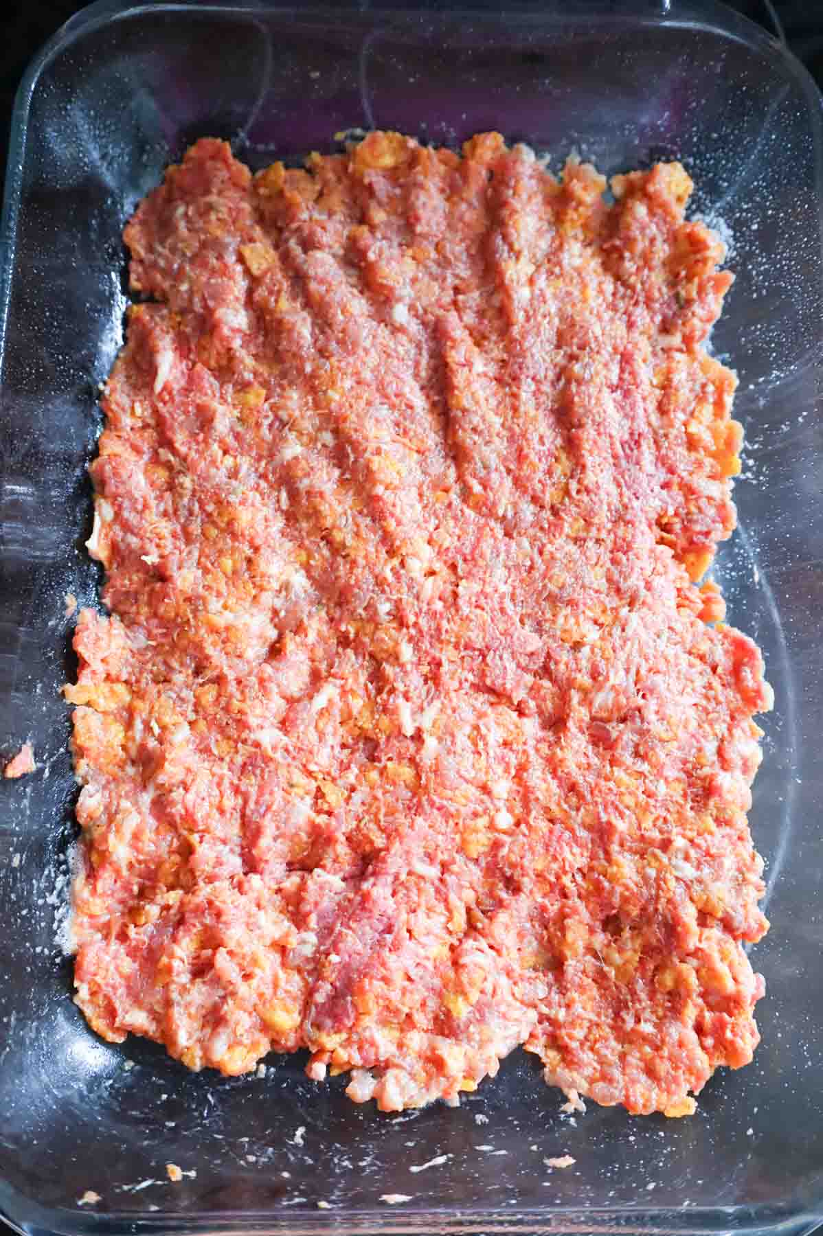 dorito meatloaf mixture pressed into the bottom of a baking dish