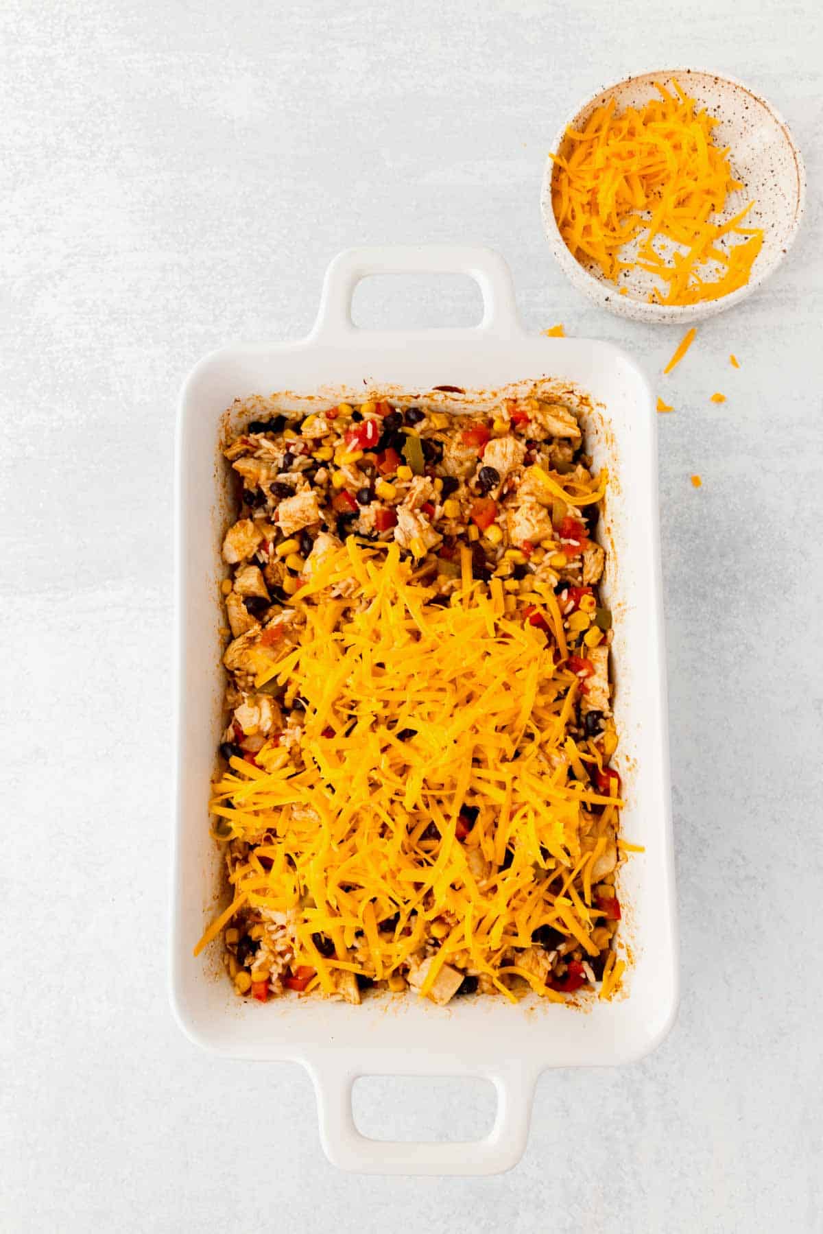 shredded cheese on top of chicken and rice casserole