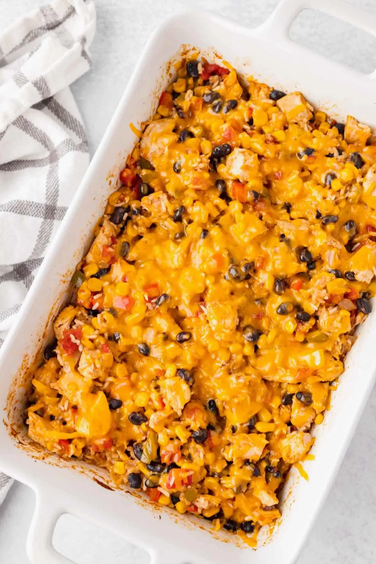 Fiesta Chicken Casserole is a hearty chicken and rice casserole loaded with diced bell peppers, Rotel, black beans, corn and cheddar cheese.